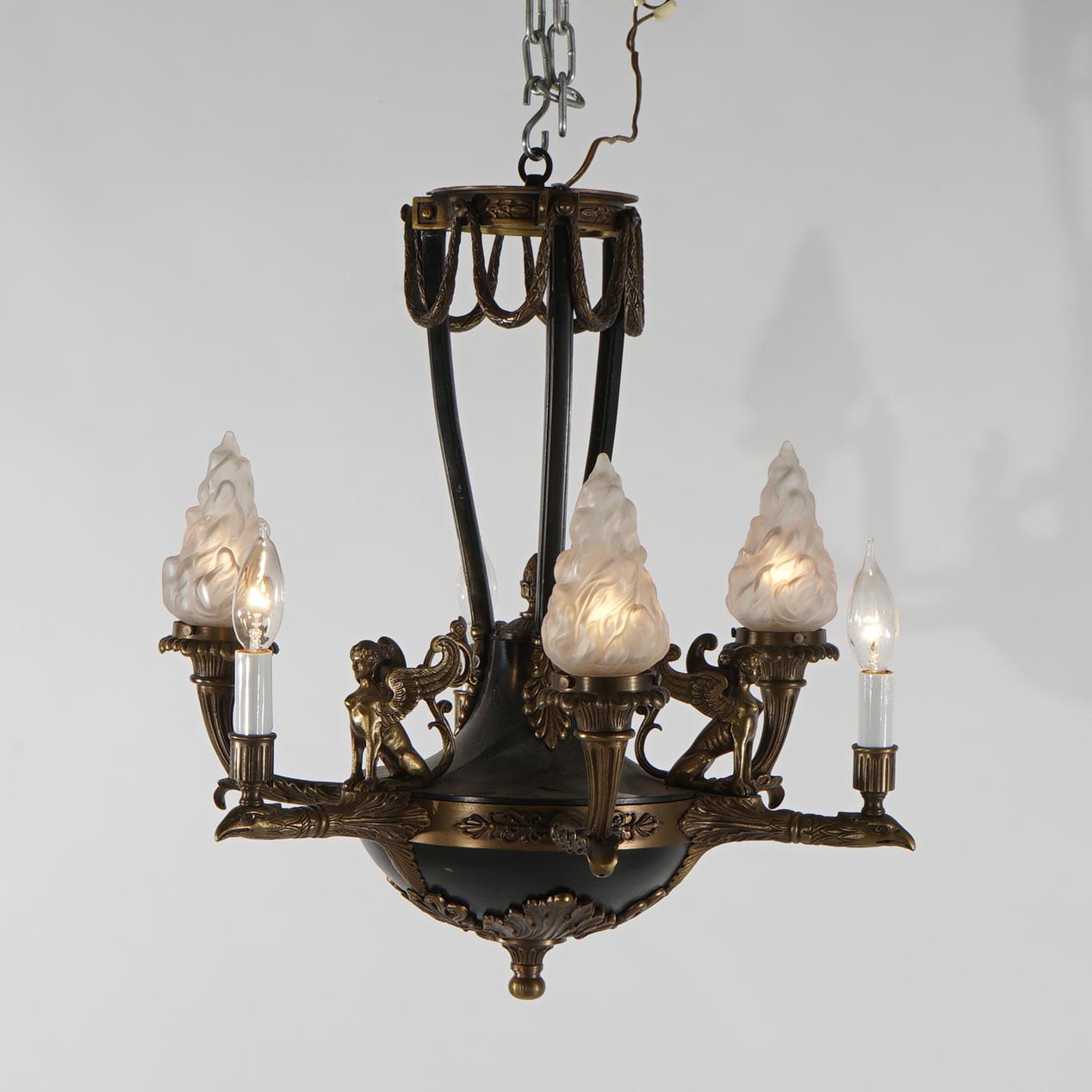 Antique French Empire chandelier with bronzed  frame, ebonized urn form font, cornucopia form lights terminating in glass flame form shades and figural sphinx elements, C1930

Measures - 20.75