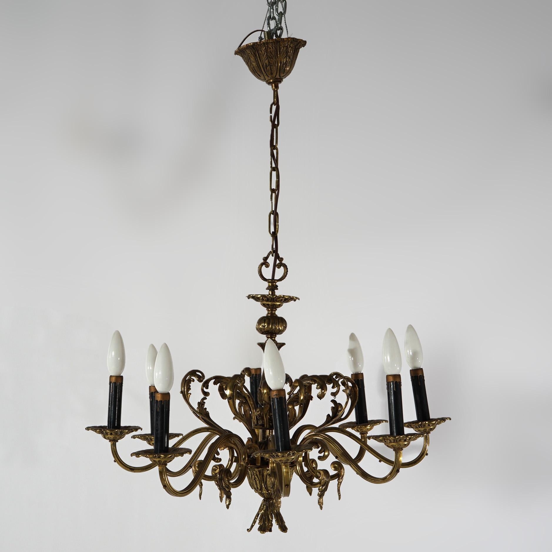An antique French Empire chandelier offers bronzed metal frame with eight scroll form arms terminating in candle lights, foliate elements throughout, c1940

Measures - 33