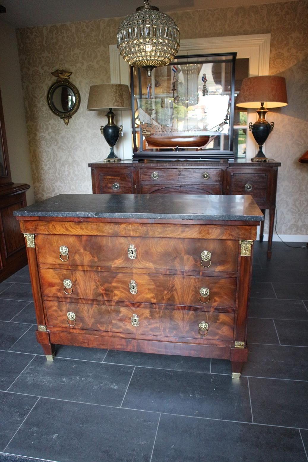 Antique French Empire chest of drawers with natural stone top. Chic chest of drawers with a beautiful warm color. Nicely explained mahogany pattern. Chest of drawers is in good and original condition. One side has some old tears.

Origin:
