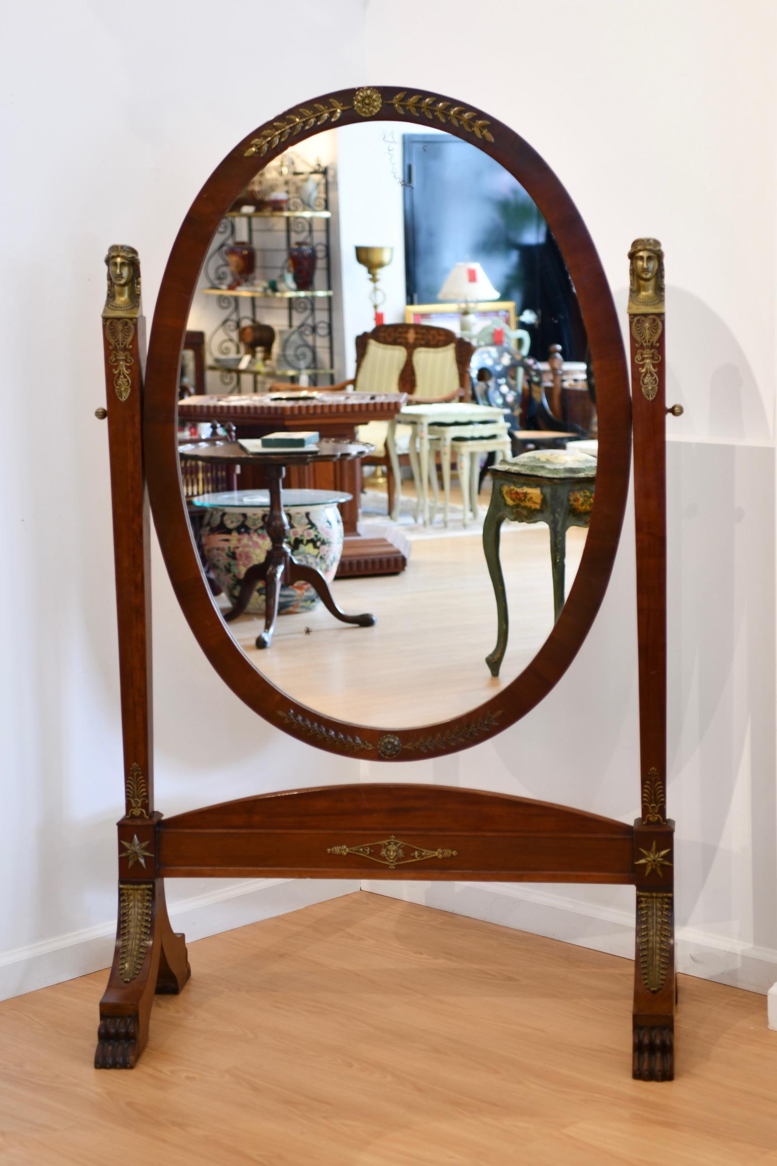Antique French Empire style cheval mirror with claw feet and figural bronze accents, circa 1900. Repairs at one joint; some minor speckling to mirror glass. Dimensions: 65.5