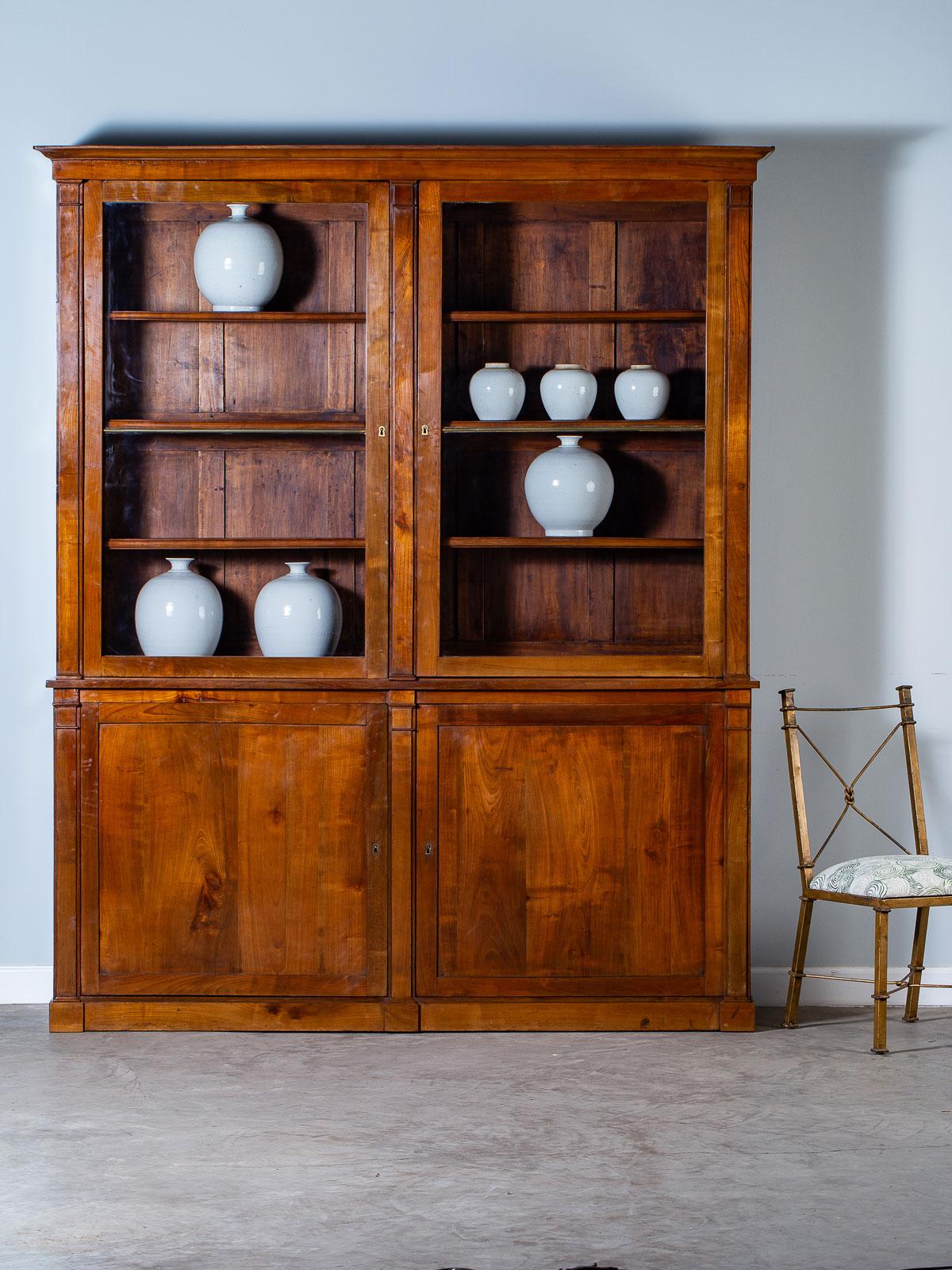 A superb antique French Empire Directoire period cherry bookcase bibliotheque display cabinet circa 1800. Please enlarge the photographs to see, in detail, the elegant simplicity of this French bookcase. Carefully chosen timber, an eye for design
