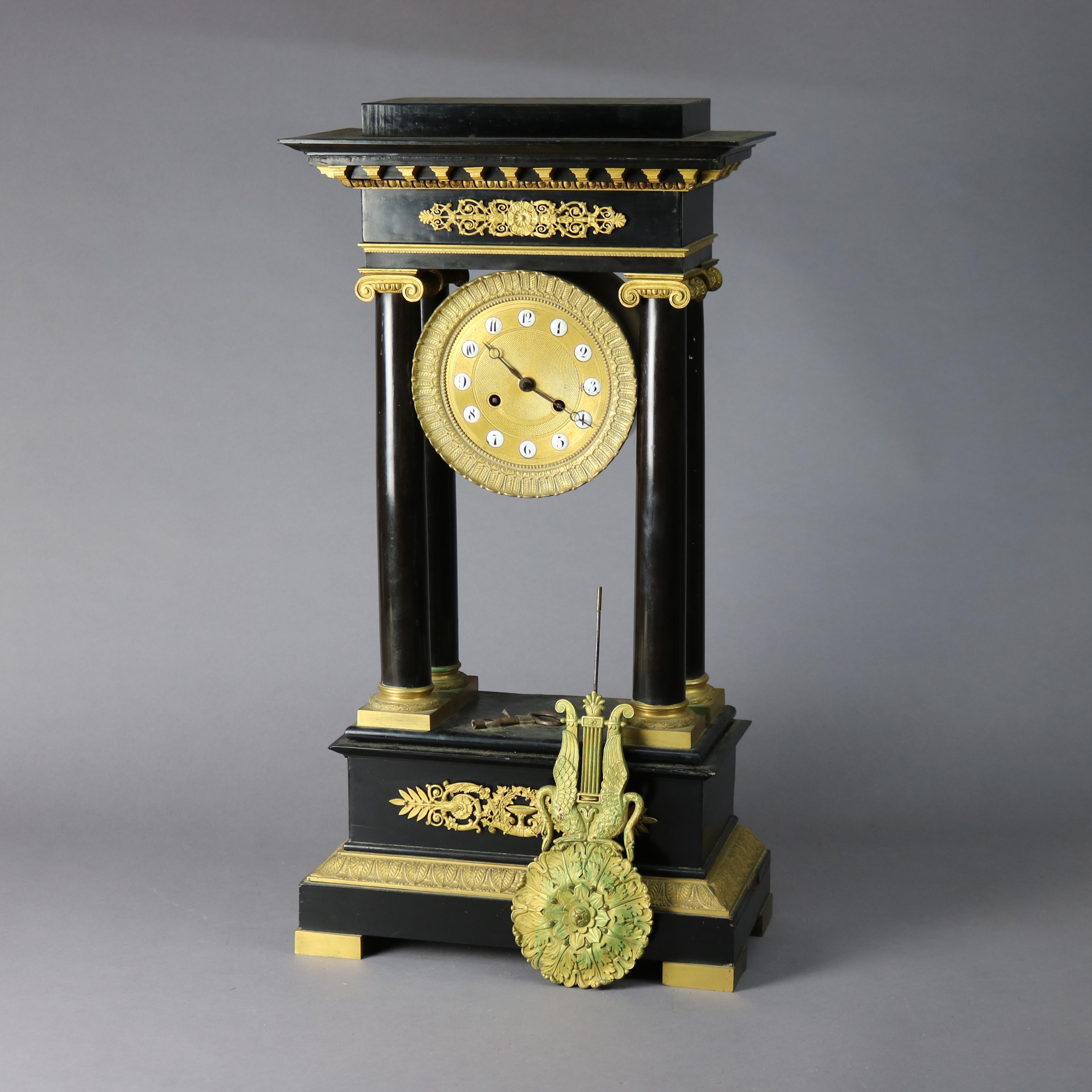 An antique French Empire portico clock offers ebonized construction with four Corinthian column supports and foliate cast ormolu mounts throughout, key as photographed, c1820

Measures - 25.75