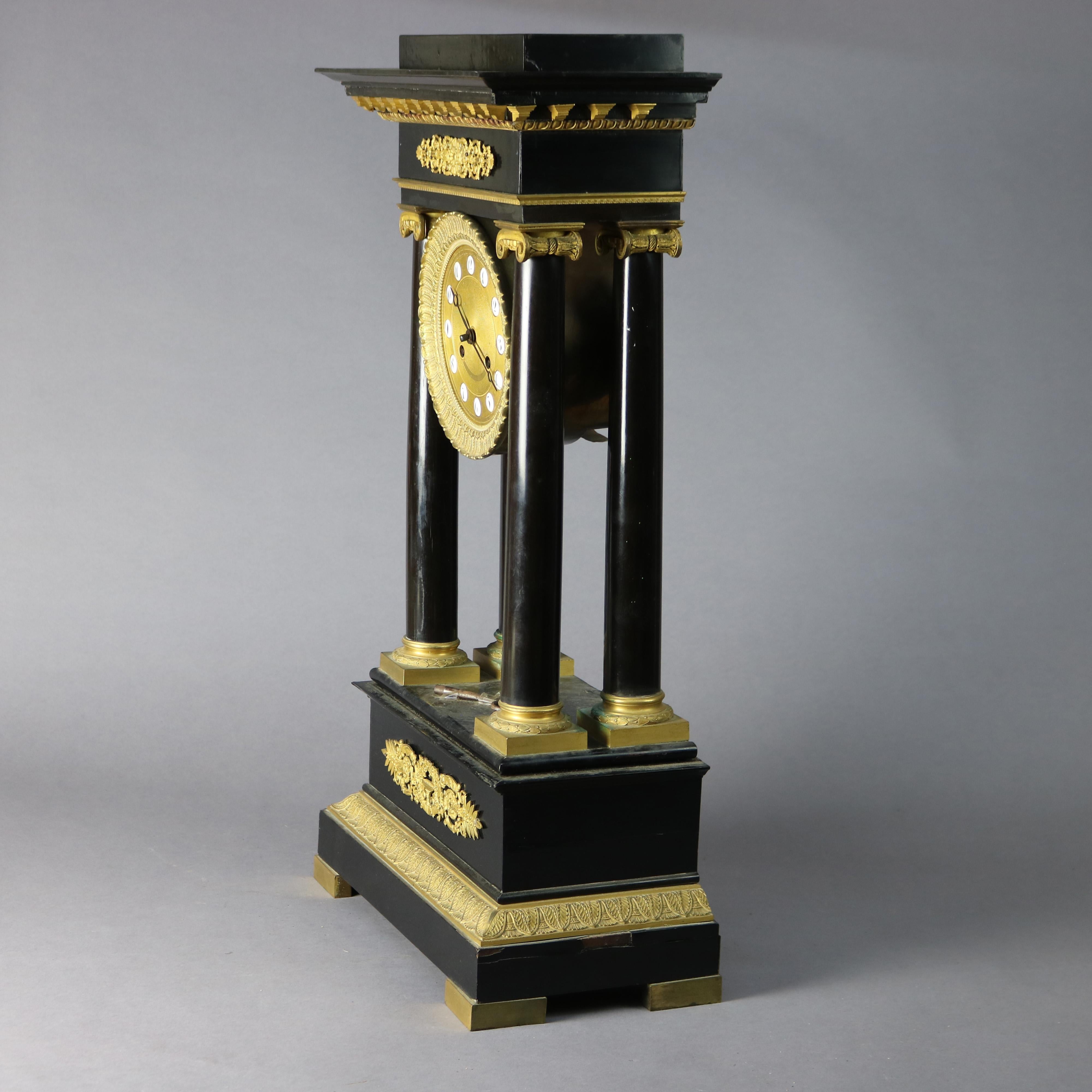 XIXe siècle Pendule de cheminée française ancienne de style Empire en portico ébénisé et doré, vers 1820 en vente