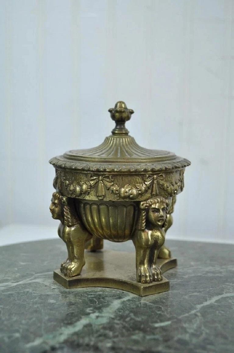 Antique French Empire Figural Bronze Sphinx Green Marble Desk Top Double Inkwell. Item features decorative cast bronze sphinx like figures all mounted on an oval green marble base which rests on small bronze feet. Circa Early 20th Century.