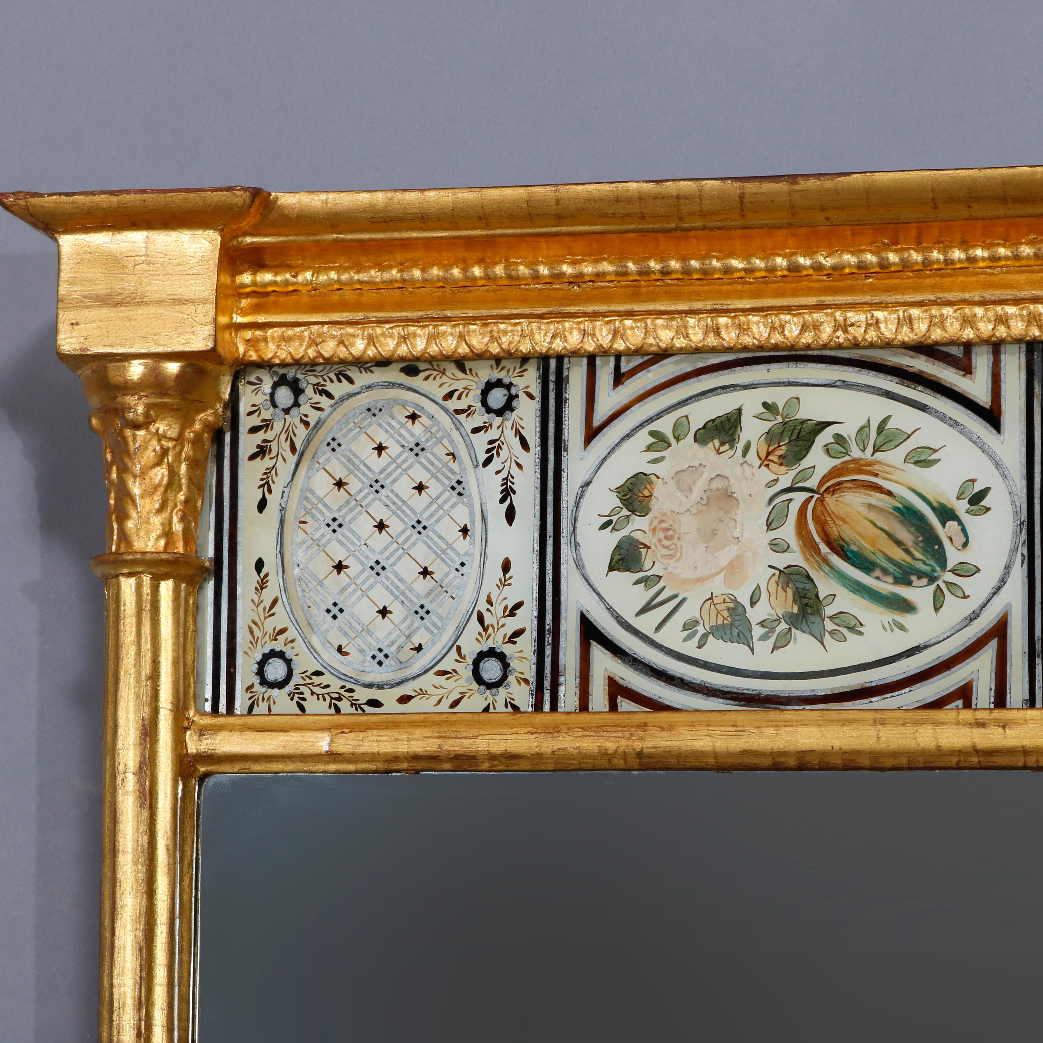 An antique French Empire trumeau wall mirror offers giltwood frame having flanking Corinthian columns with acanthus capitals, upper floral painted églomisé glass panel and lower mirror panel, 19th century.

Measures: 31.63