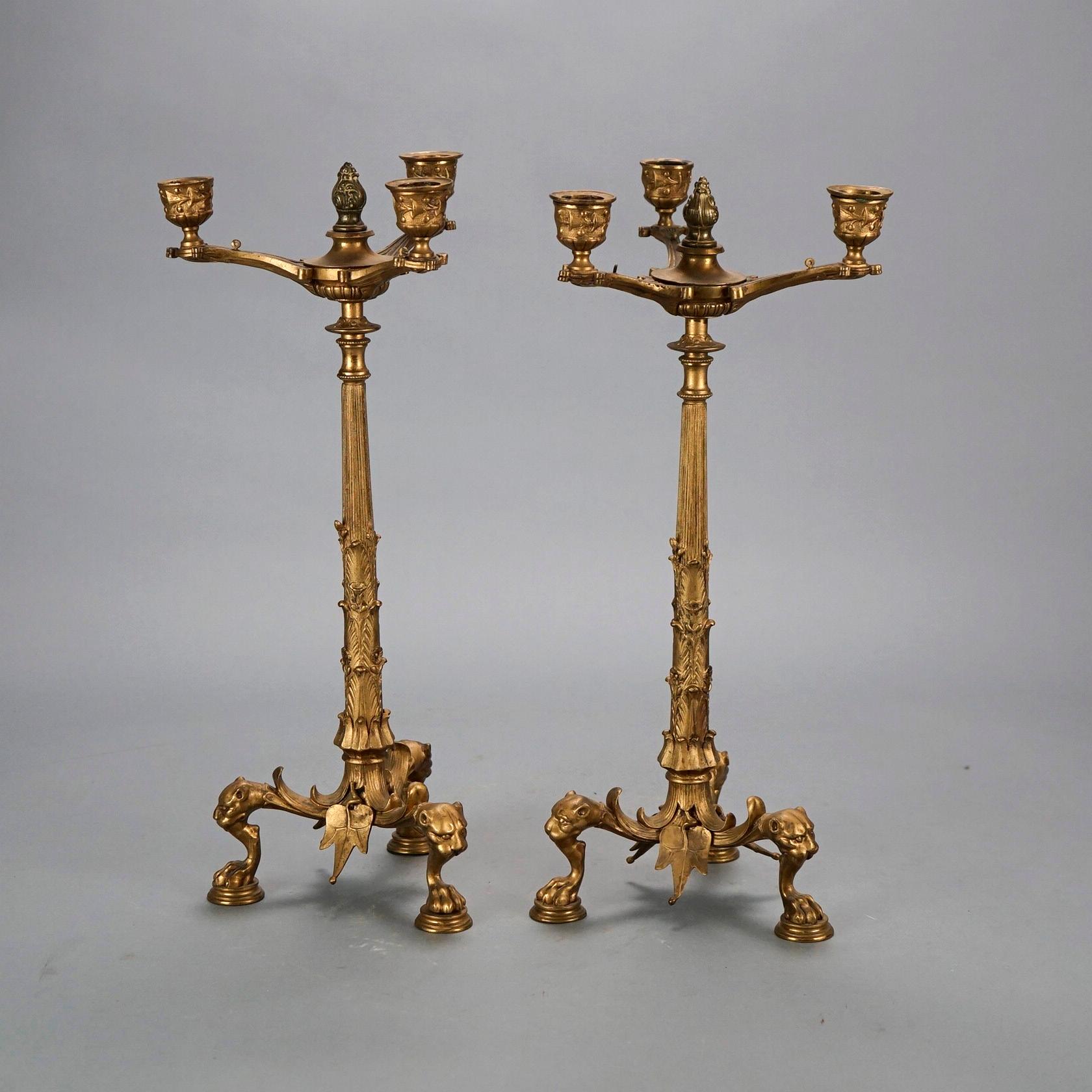 An antique Classical cast bronze figural candelabra offers three candle sockets, raised on foliate form column with base having lion masks at knees and paw feet, foliate elements throughout, 19th century

Measures- 16.75''H x 7''W x 7''D