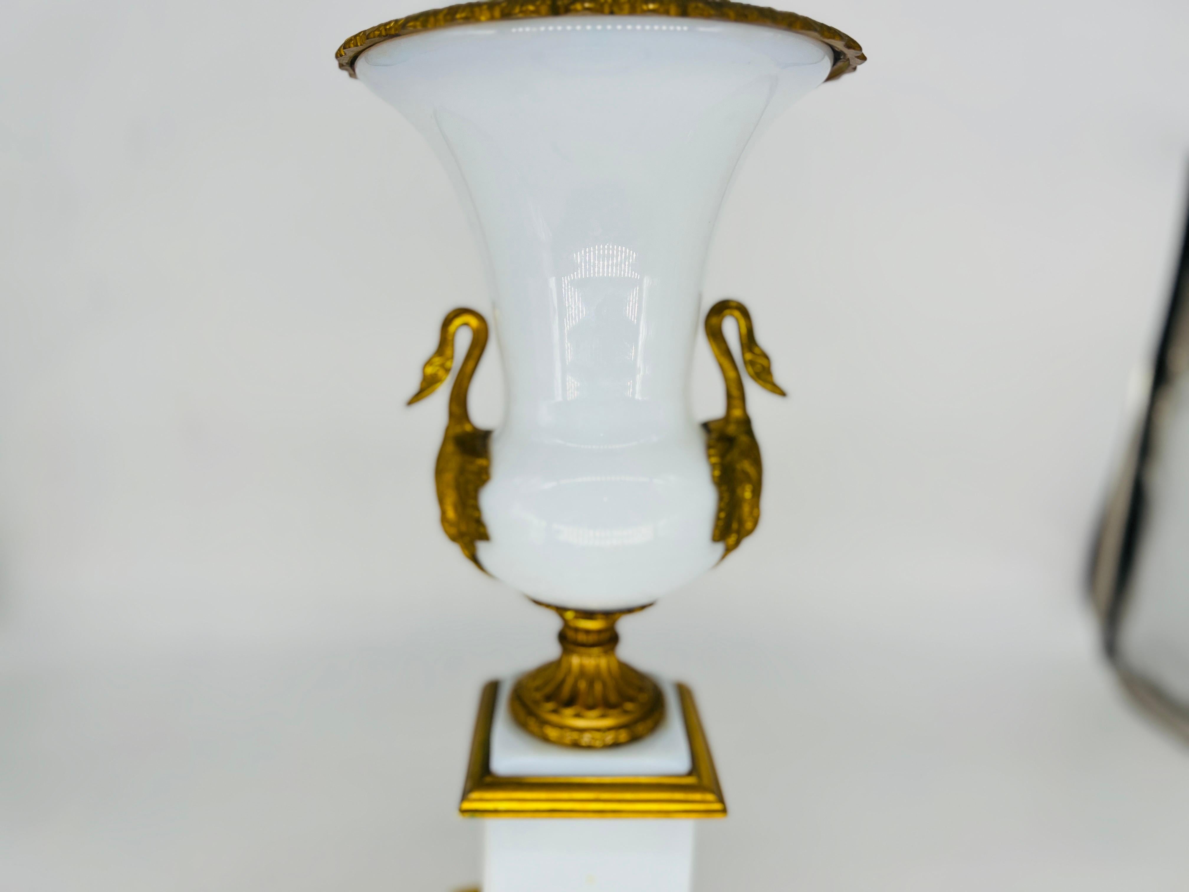French, circa 1910. A good quality French empire table lamp with white opaline glass body with gilt bronze mounts and swan form handles to central opaline glass body. Marked to bottom “Made in France”.