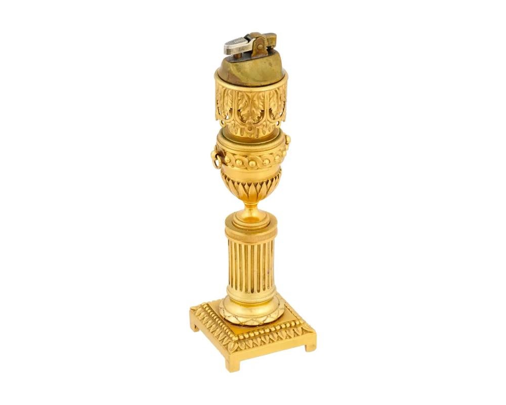 An antique 19th-century French gilt bronze desktop lighter stand. Footed base, fluted column body with a baluster vase intersection, acanthus leaf decor on top. The piece is set with a modern Japanese gas lighter. Marked RF, 1-620, 4550 on the