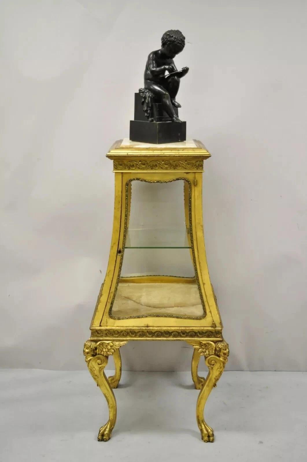 Antique French Empire Winged Cherub Gold Gilt Vitrine Curio Cabinet. Item features onyx stone top, angel/cherub legs with wings, paw feet, distressed gold gilt finish, glass on all sides, 1 swing door, no key, but unlocked, 1 glass shelf, very nice