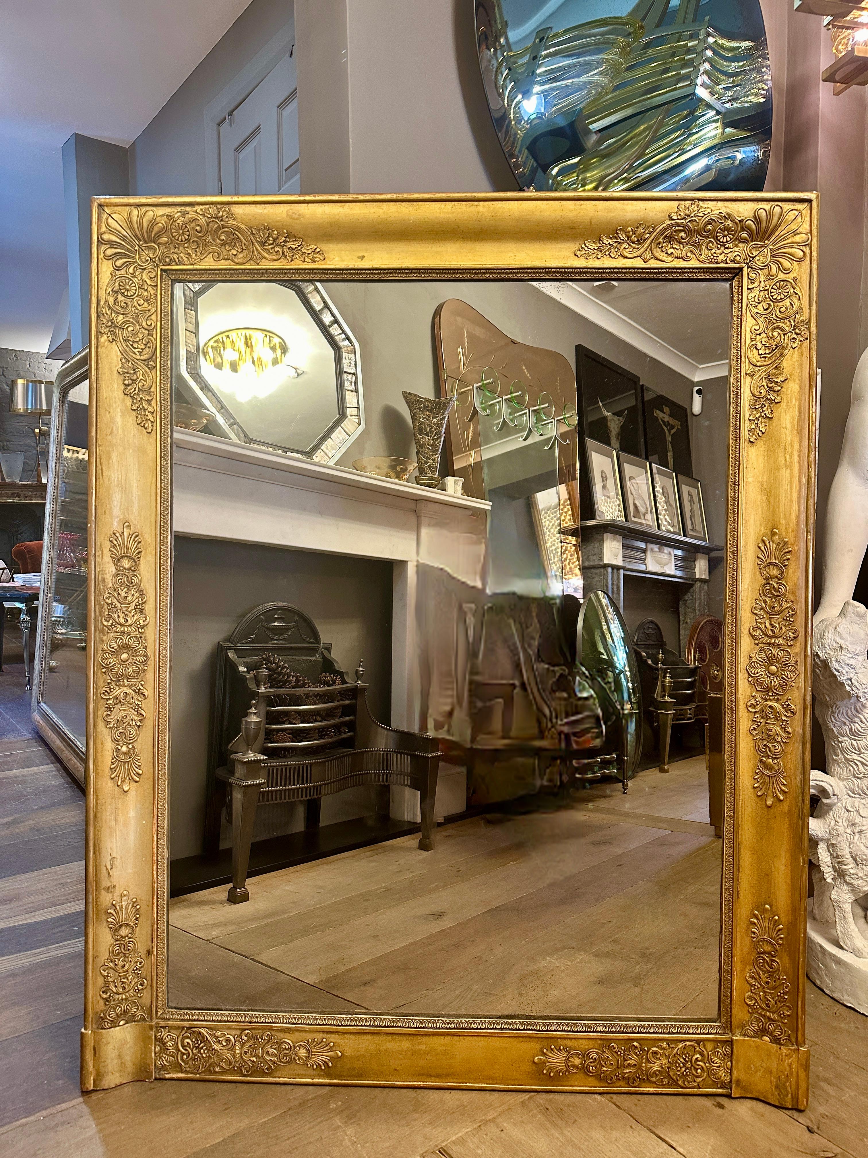 Espejo antiguo Imperio Dorado de buen tamaño con motivos decorativos aplicados en dorado sobre un marco rectangular, deslizamiento interior con diseño de lengua de cordero. Espejo en buen estado. Lomo original entablado. Retirada de una habitación