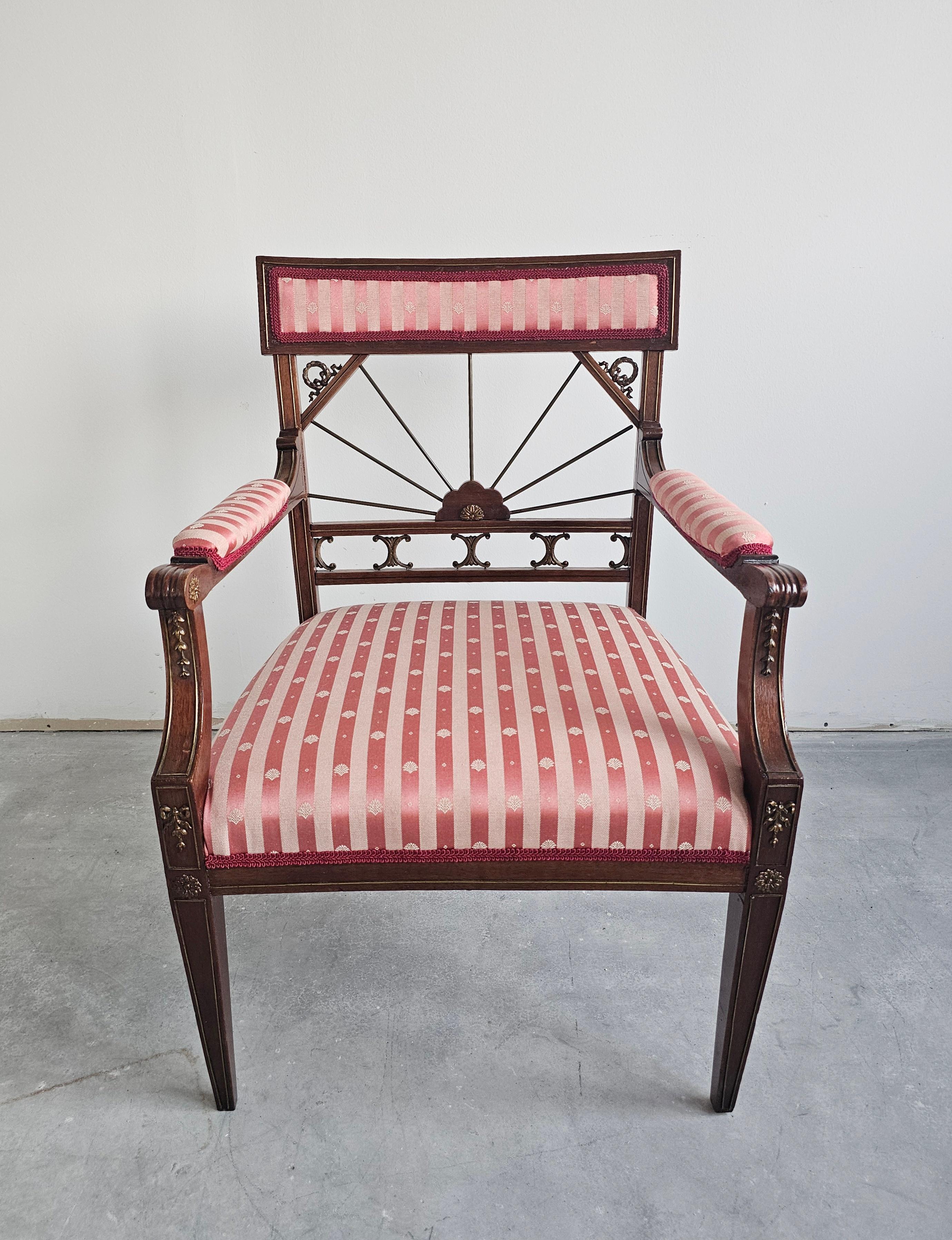 In this listing you will find a gorgeous French Empire style armchair done in mahogany and upholstered in striped fabric in dusty rose and pale pink with seashell motif. The chair has beautiful bronze details and backrest that was designed to