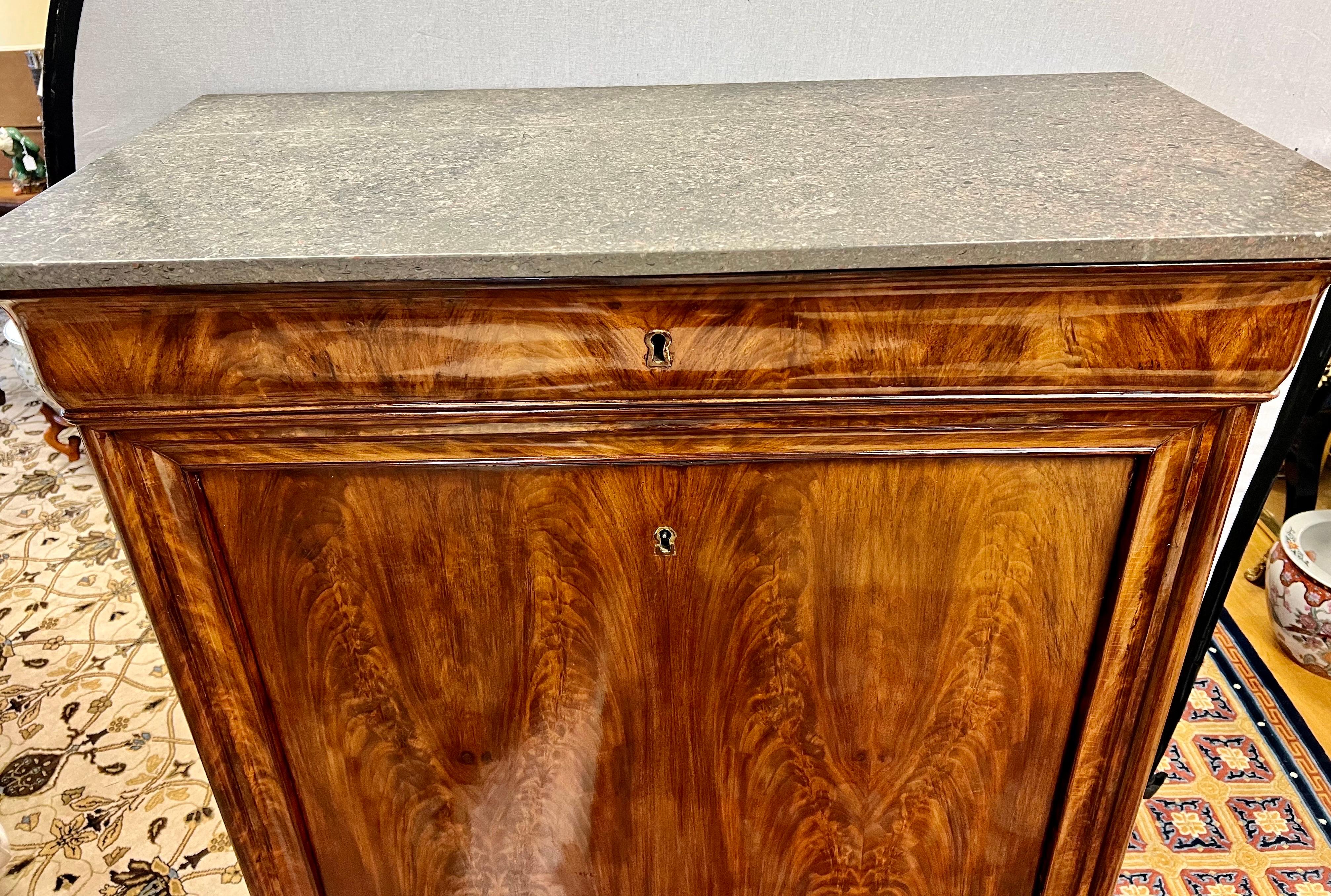 Exquisite tall 19th century French Empire mahogany secretaire abattant which features elegant patterns, created by the rich mahogany grain, and a drop down with black leather writing surface. It features multiple cubbies and small drawers as shown.