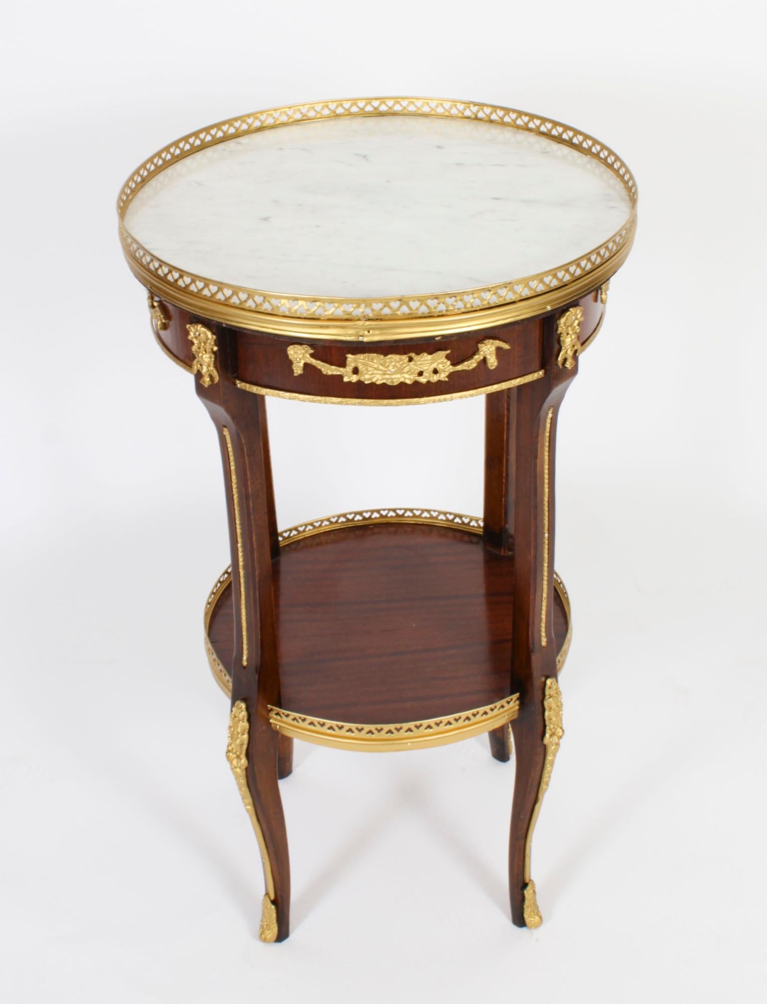 This is a beautiful antique French Empire Revival circular occasional table with ornate ormolu decoration and a beautiful inset white 