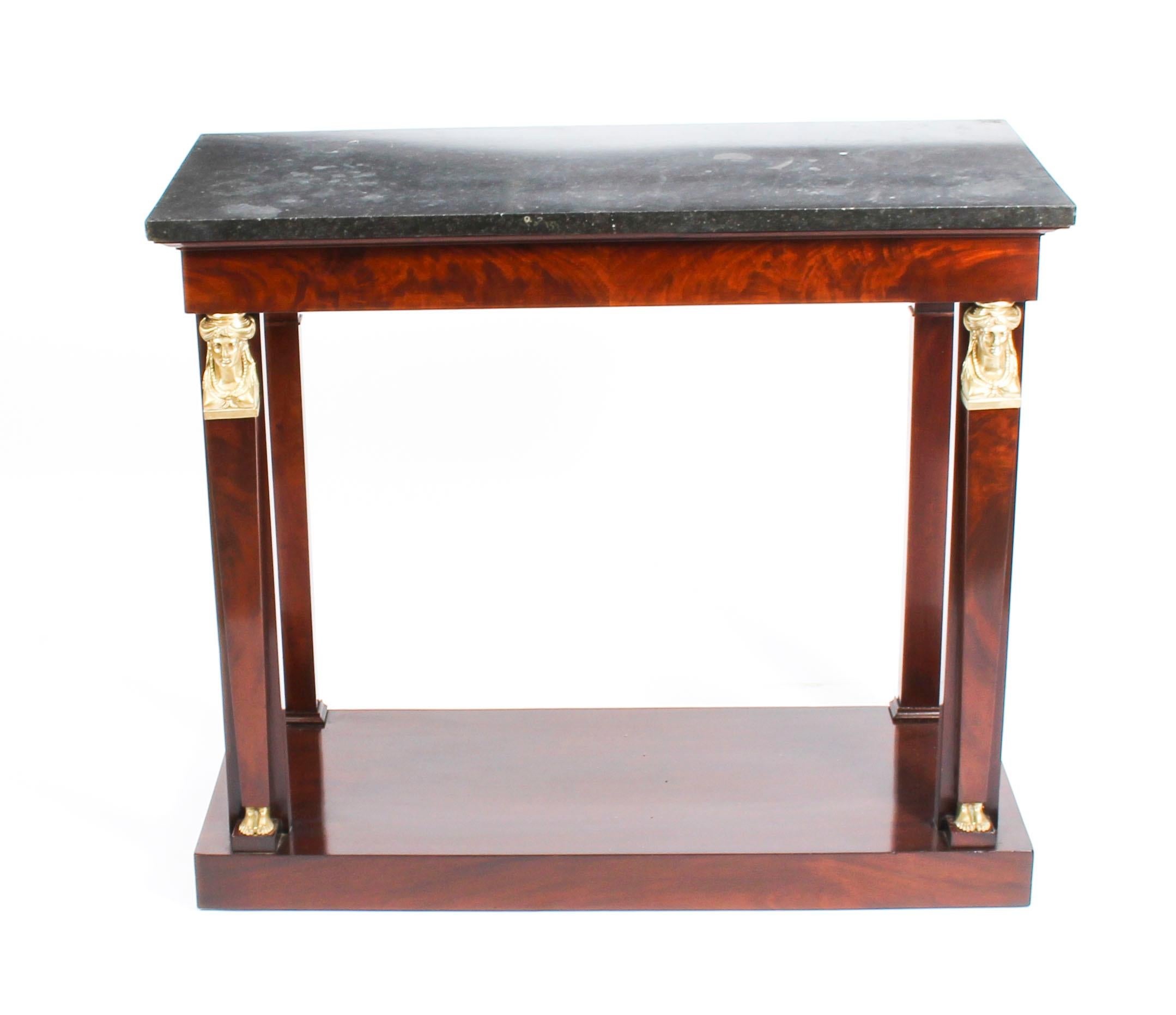 This is an elegant antique French Empire flame mahogany and ormolu mounted console table with a distinctive Belgian fossil marble top, circa 1810 in date.

This magnificent table has beautiful decorative ormolu Egyptian revival neo-classical