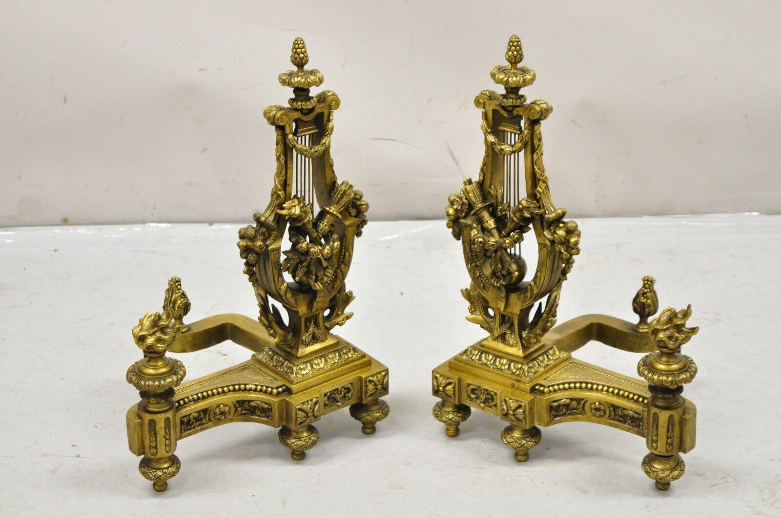 Antique French Empire Neoclassical Style Bronze Figural Lyre Harp Andirons - una coppia. L'oggetto in questione ha un notevole dettaglio in bronzo fuso con accenti di fiamme e torce, drappeggi floreali, forma centrale ad arpa, una coppia antica
