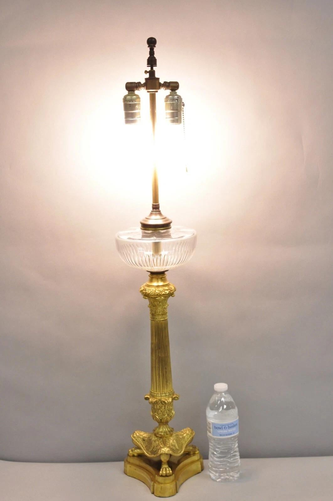 Ancienne lampe de table Empire néoclassique en bronze doré Figural avec pied de patte, insert en verre et épi de faîtage ajustable en hauteur. Circa Early 20th Century. Dimensions : 35,5