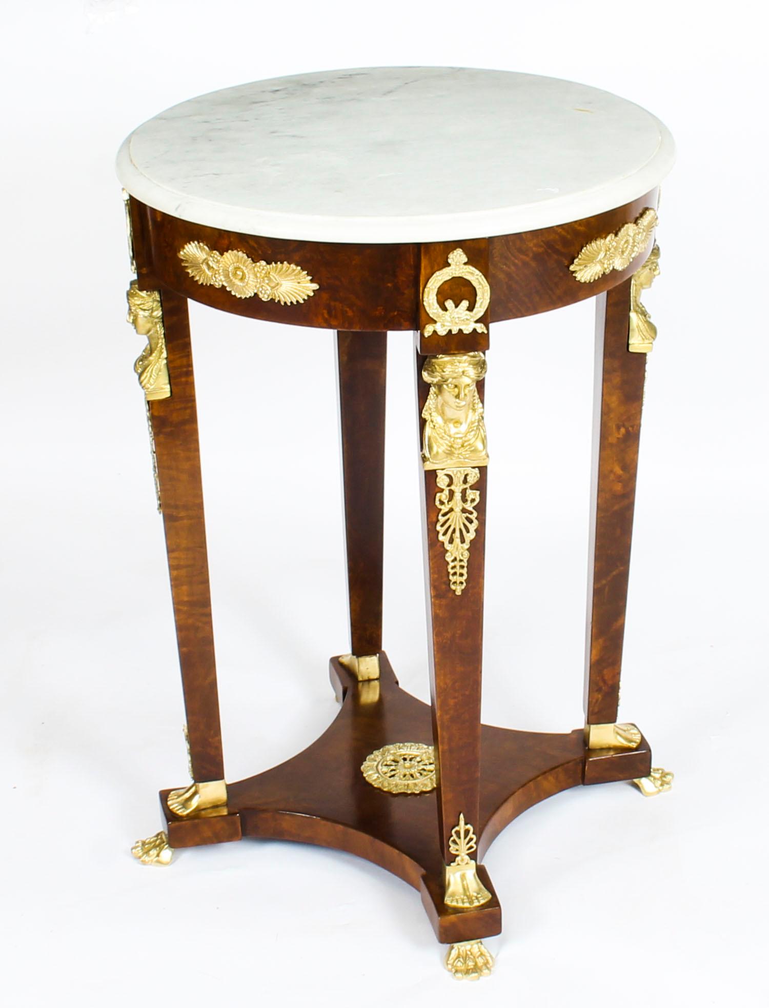This is a beautiful antique late 19th century French Empire Revival circular marble top guéridon decorated with ormolu mounts.

The white and grey circular marble top above square form tapering legs with ormolu caryatid mounts. The quadripartite