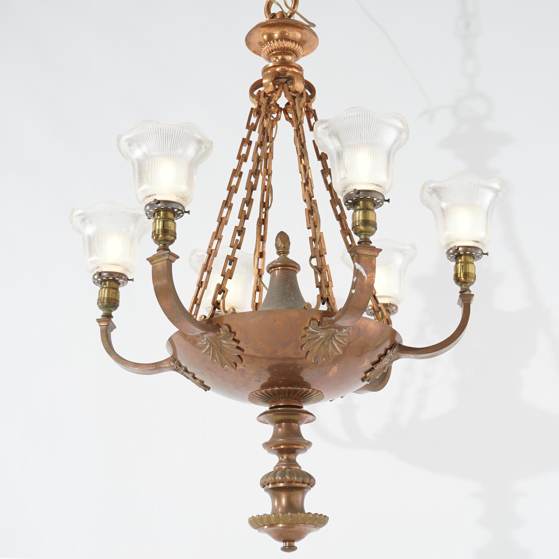 An antique French Empire style hanging pan chandelier offers bronze frame with six foliate form arms terminating in lights with glass shades, c1920

Measures- 41.5''H x 30.5''W x 30.5''D