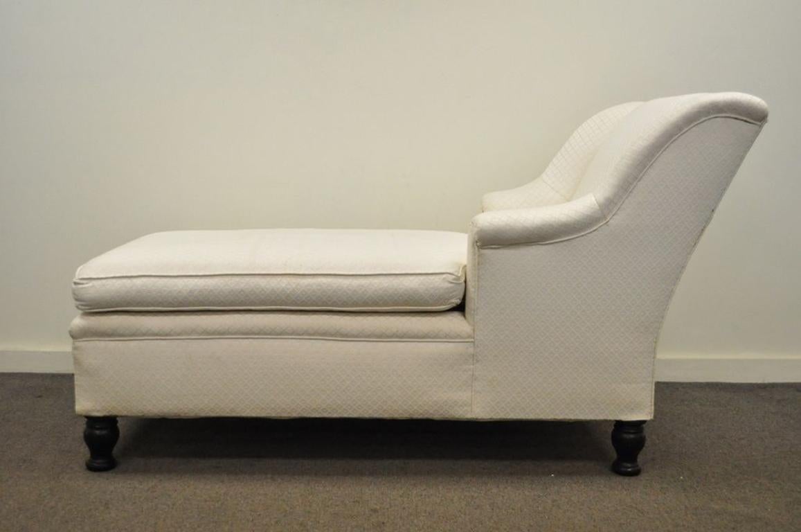 Lovely antique chaise longue/fainting couch in the French Empire taste. The piece features a dramatically flared back with staggered armrests, clean lines, and solid wood carved bun feet, circa early 1900s. Measurements: 34.5