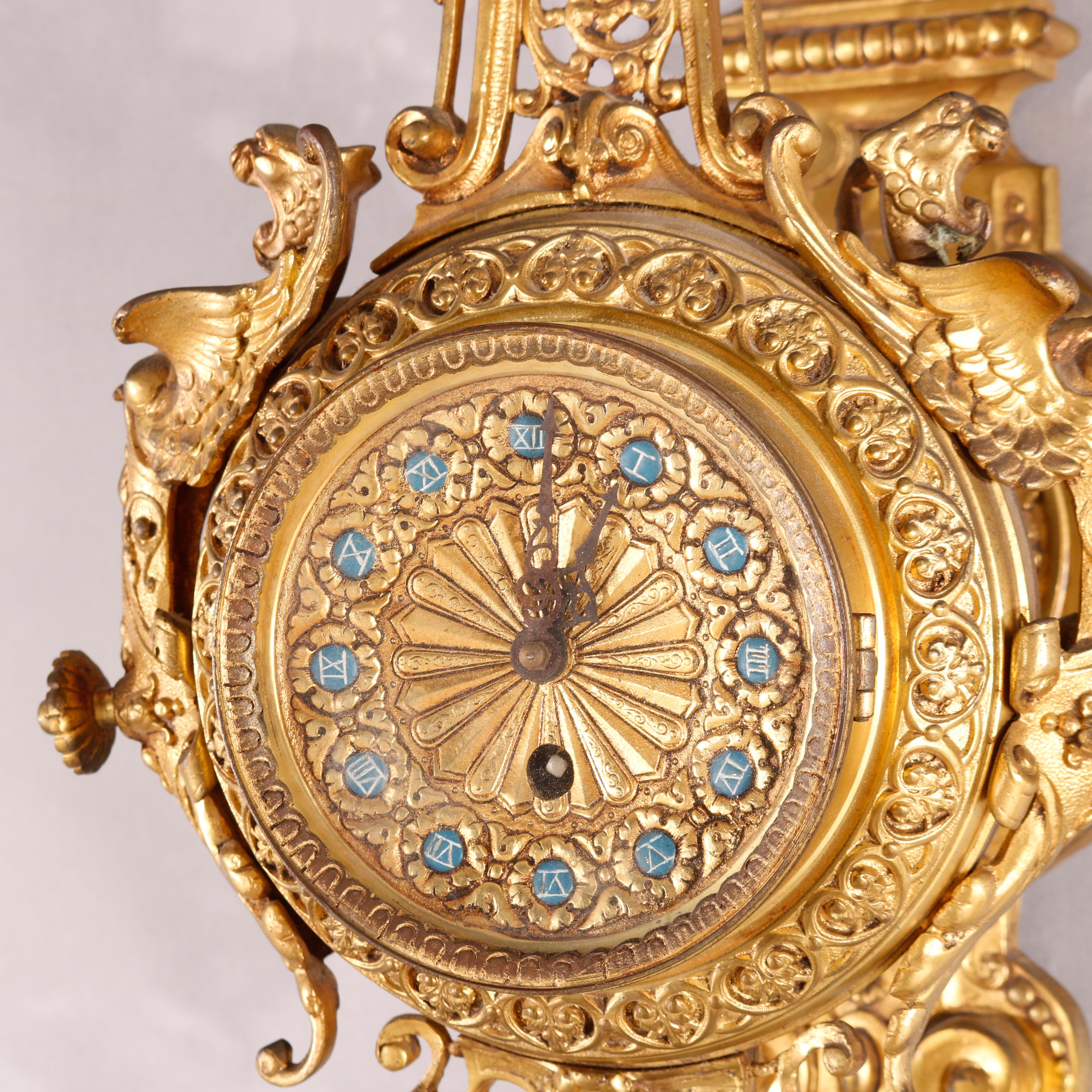 An antique French Empire style hanging clock offers gilt bronze construction with scroll and foliate elements throughout as well as flanking figural griffins on case, non-working, circa 1880

Measures - 31