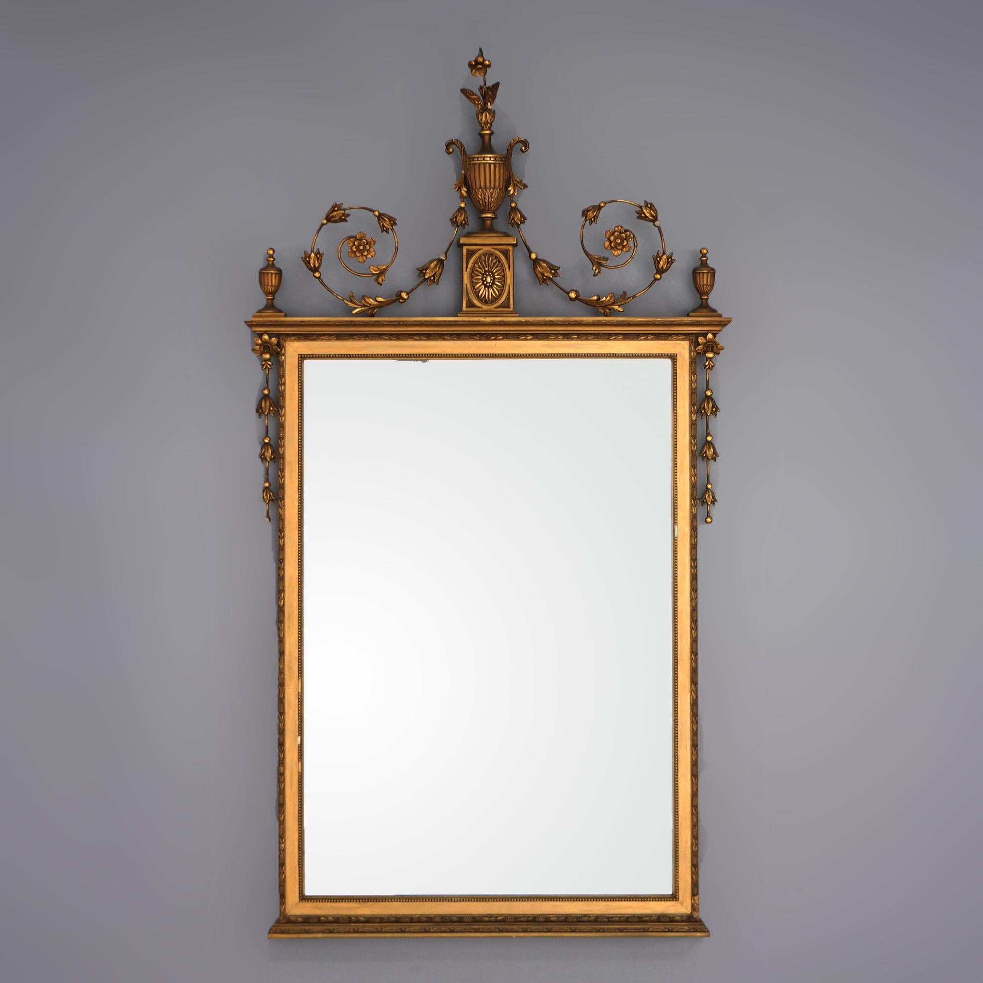 An antique French Empire style wall mirror offers giltwood frame with Grecian urn, bellflowers and foliate elements, c1900
 
Measures - 52.25