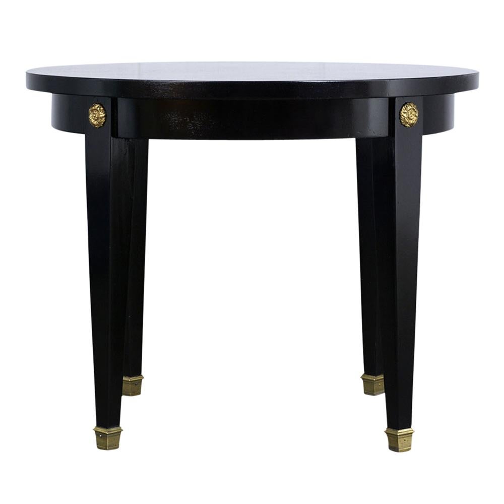 This is a lovely, 1900s French Empire round side table. Made from mahogany wood, newly stained in a deep black color, lacquered finish. Brass decorations on the corners. Long cubic legs, finished with brass toe caps. The table is solid and sturdy,