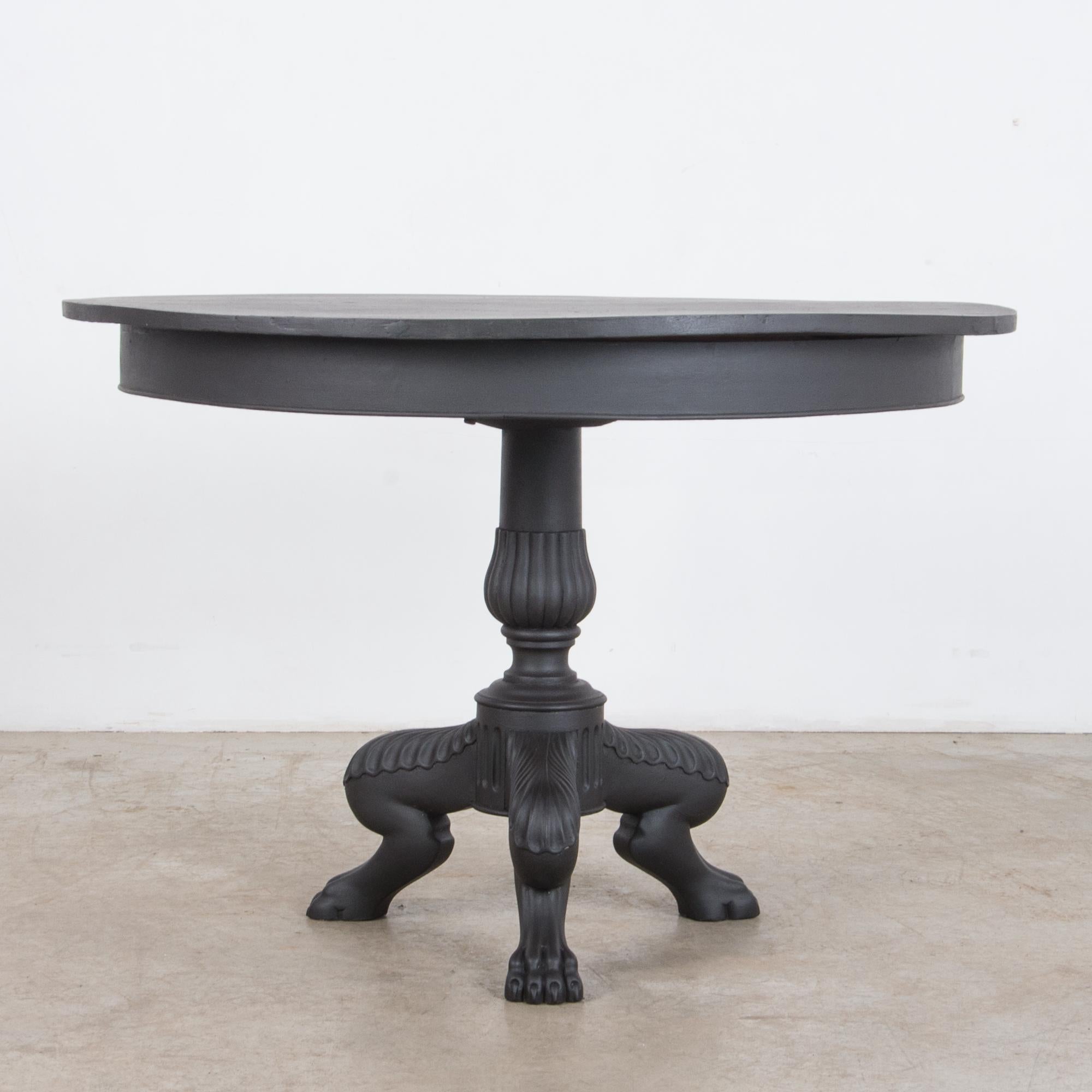 This figurative carved table is painted in contemporary matte black from France, circa 1820. A Provincial design, features a blend of styles with a neoclassical influence. Zoomorphic table legs and classical decorations are combined with a simple