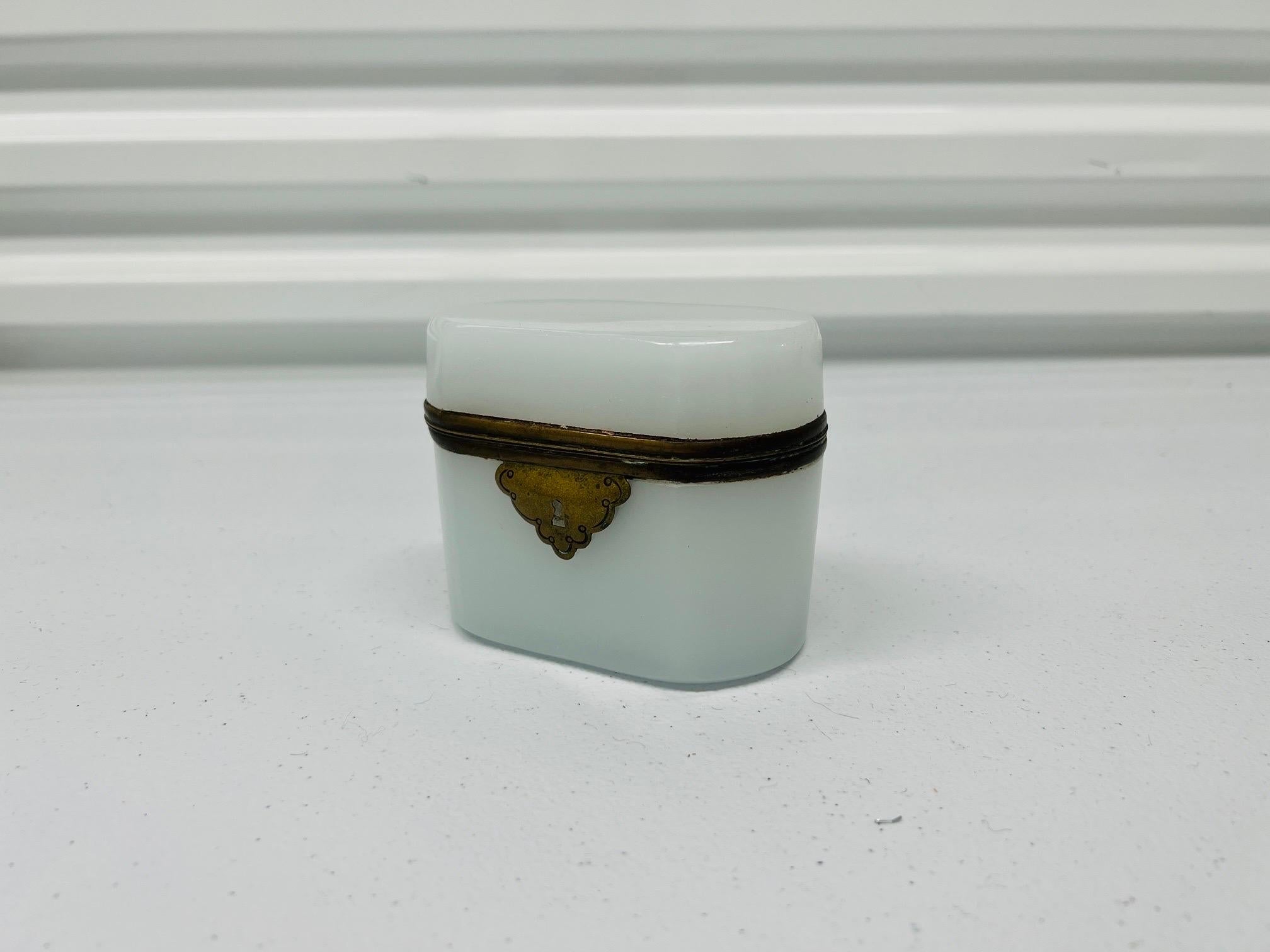 French, 19th century.

A good quality antique empire style white opaline box with silvered collar, hinged lid and a locking mechanism. Unmarked. 