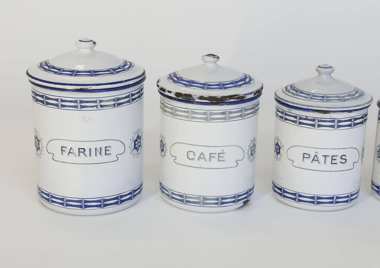 This French enamel canister set consists of five, graduated, lidded canisters. The canisters are white and blue enamel with black lettering.
Farine - Flour, 7