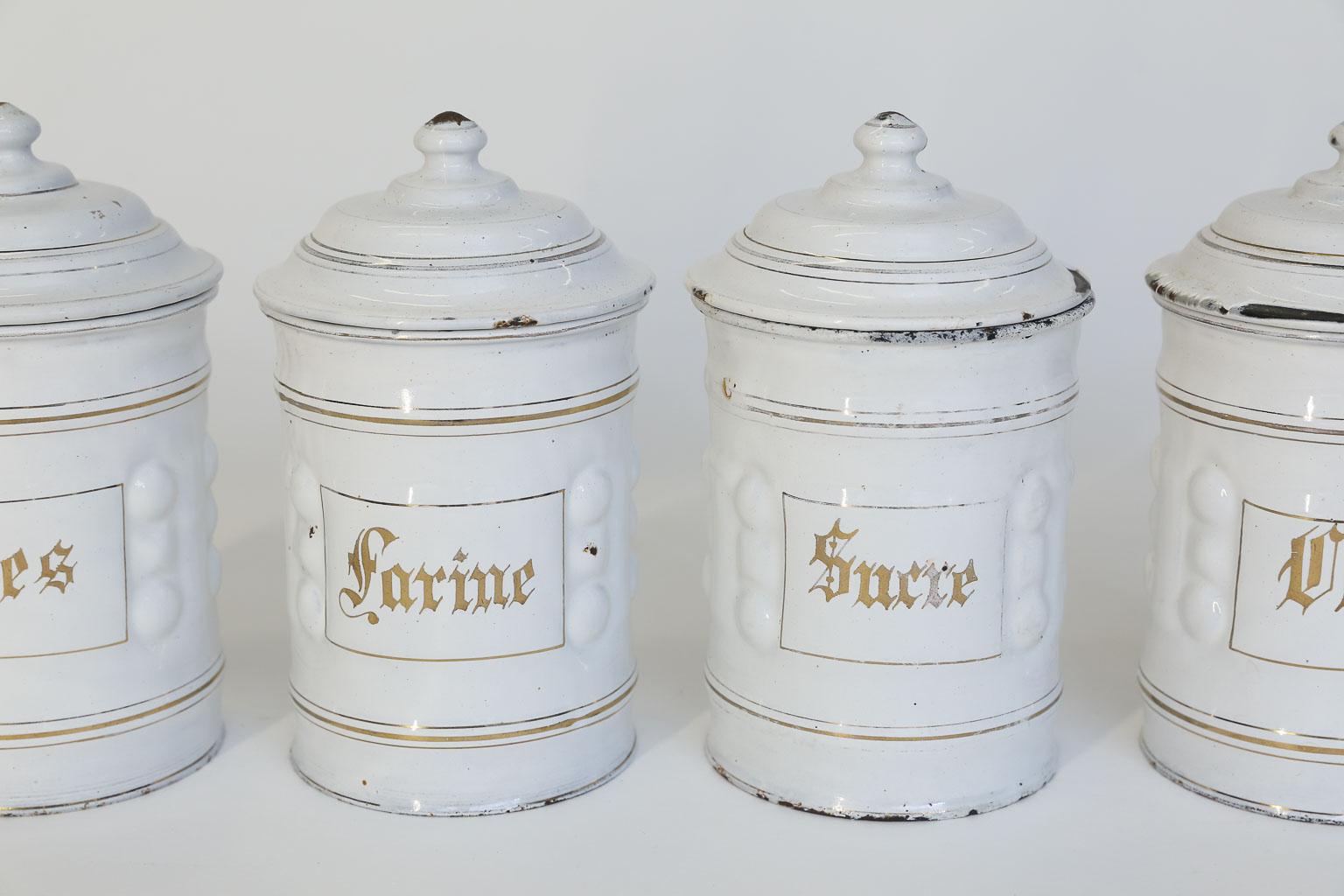 This French enamel canister set consists of four, equal size lidded canisters. The canisters are white enamel with gold lettering, Pates - Pasta, Farine - Flour, Sucre - sugar and cafe - coffee. This lovely set will surely add French charm to your