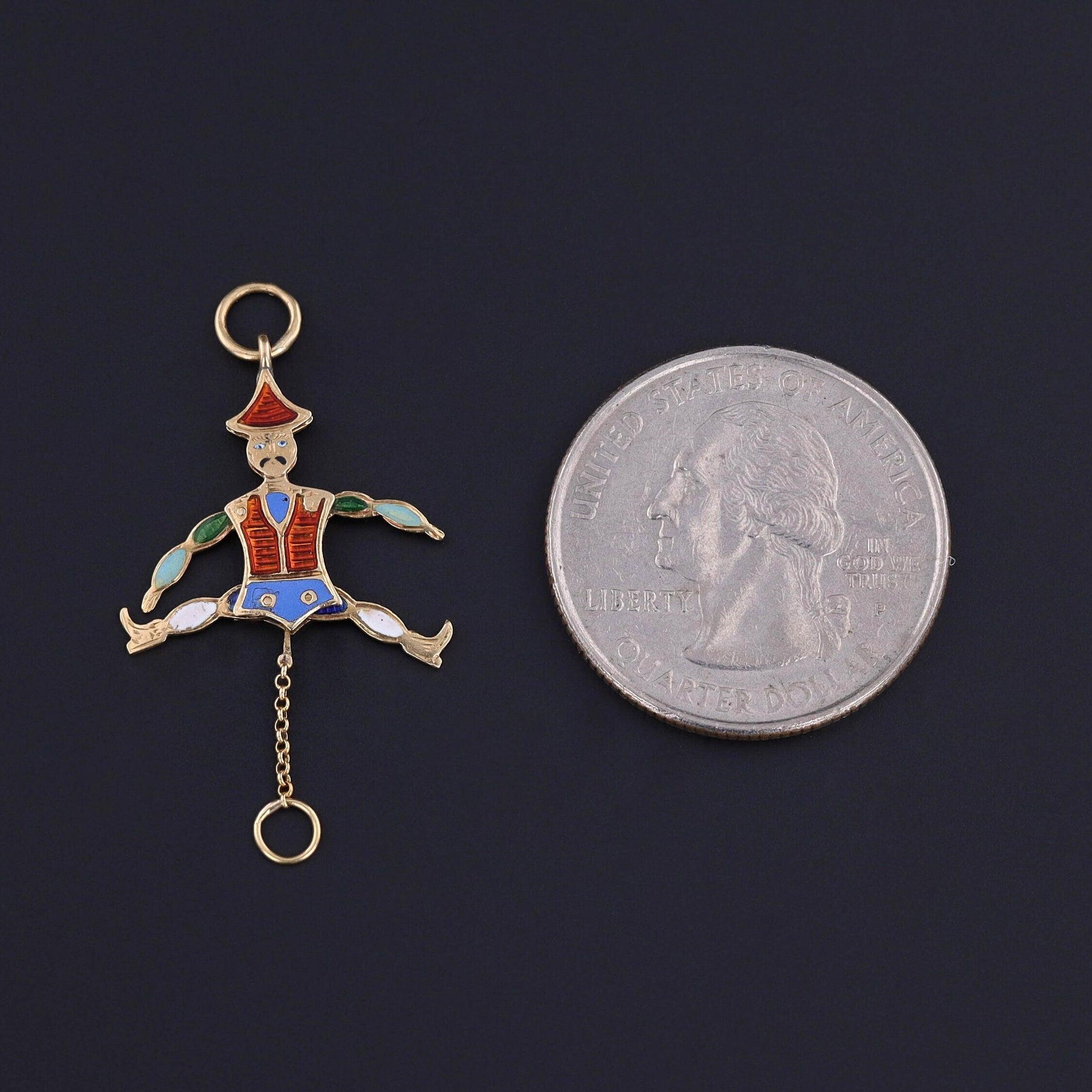 Cette breloque française ancienne en or 18 carats (vers 1870) représente un homme en émail double face qui lève les bras et les jambes lorsqu'on tire sur sa chaîne.

La pièce mesure 1,35 pouces du haut de l'anneau de saut à la base de la chaîne par