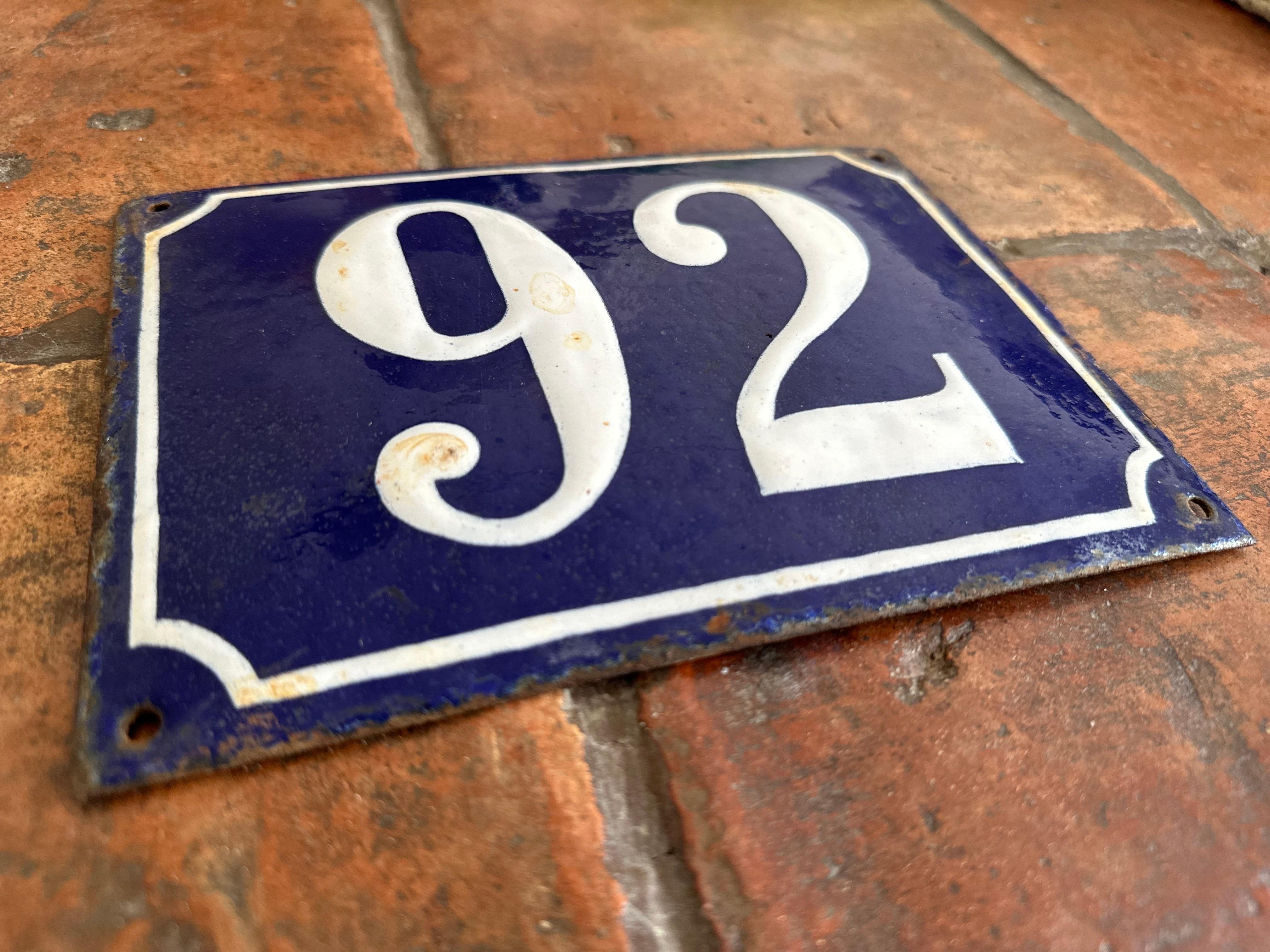 This beautiful antique French enamel house number plaque, dating from around 1900, features a classic design with a deep blue background, a bold white number, and a white border. Originally intended as an address marker, this piece exudes the charm