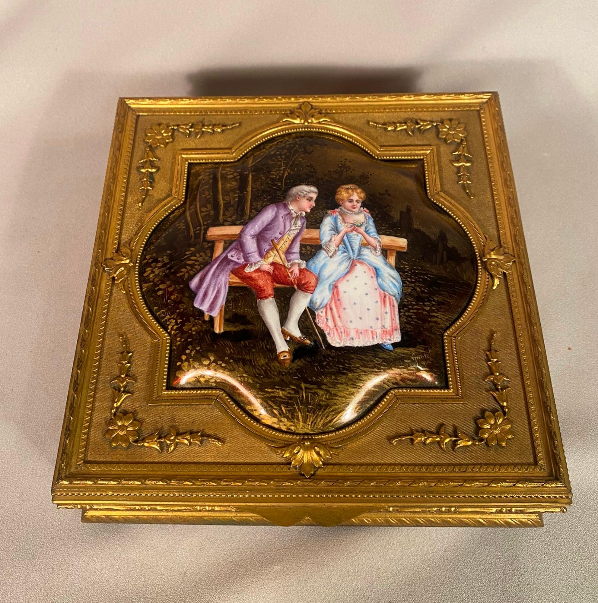 This is a stunning large antique French bronze jewelry box with an enamel painting of two classical lovers.  The enamel is signed Garnet amazing detail and quality.  The bronze work of the box is very well done.  The interior has a peach-colored