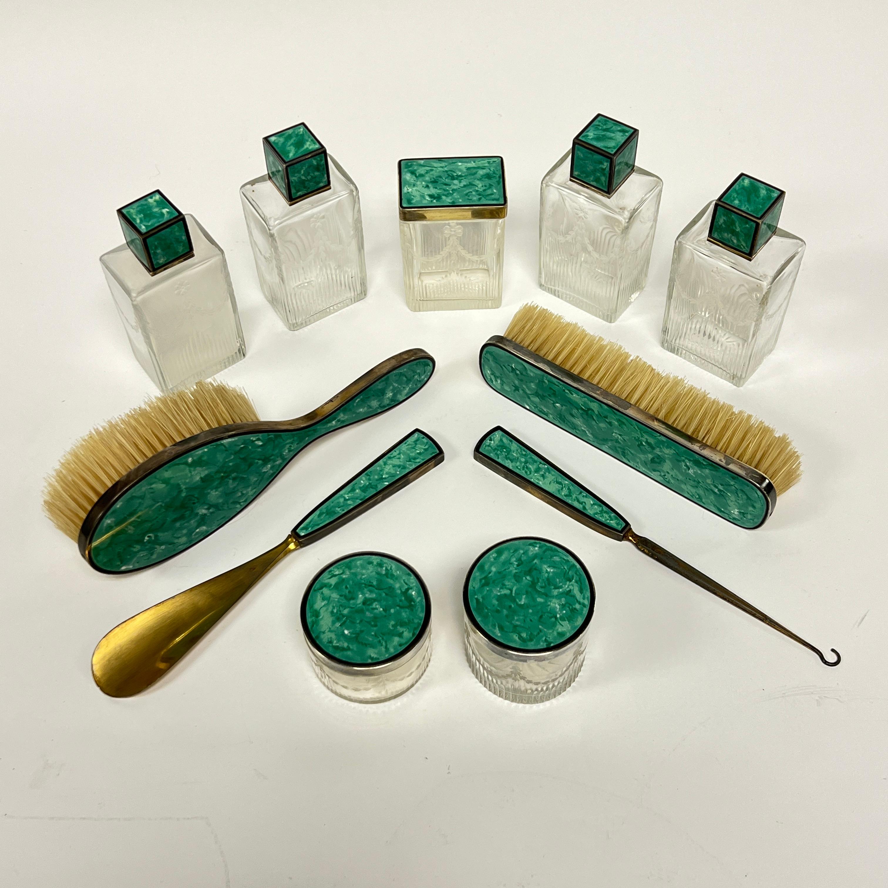 Nuestro juego de aseo francés antiguo (de principios del siglo XX) está fabricado en vidrio moldeado con motivos grabados de guirnaldas de campanillas, con monturas de plata vermeil y esmalte verde.  Se incluyen cuatro frascos de perfume con tapones