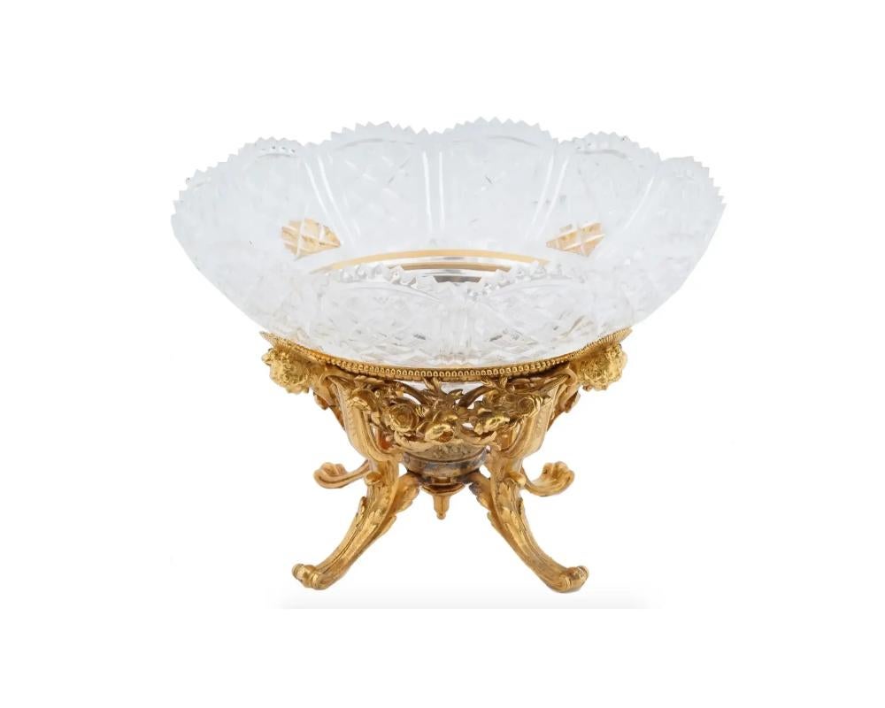 A fine antique French Empire cut crystal round shaped centerpiece bowl with a wavy edge. Mounted in a footed hand chiseled ormolu mount decorated with embossed masks, flowers and acanthus leaves. Signed to the base: Ferdinand Barbedienne, France
