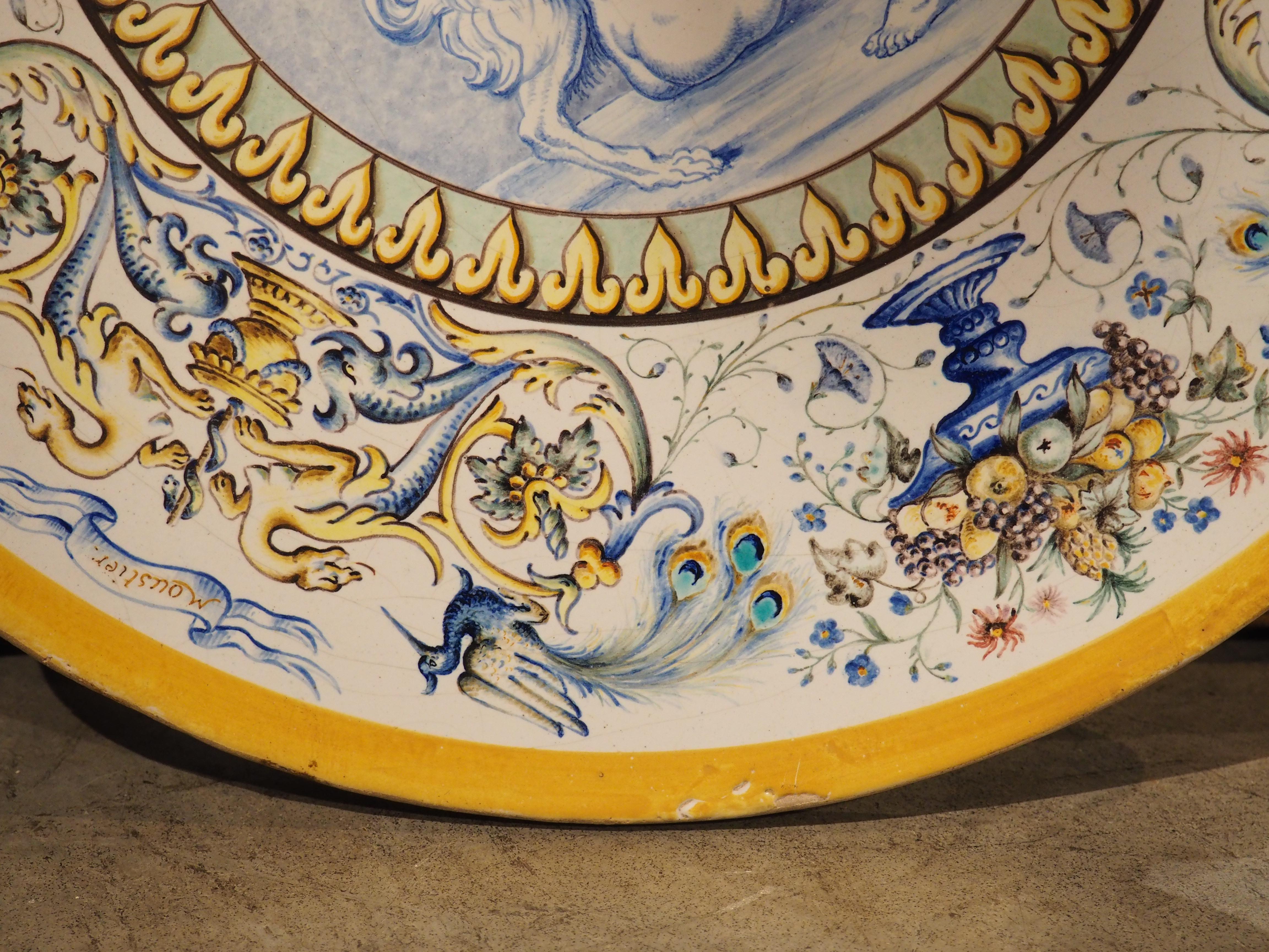 Plus d'informations bientôt...

Produit par la Manufacture de Madame Veuve Dumas (dans les années 1800), ce plat en faïence française présente un anneau vibrant d'images entourant un cartouche central dont la palette est similaire à celle de la
