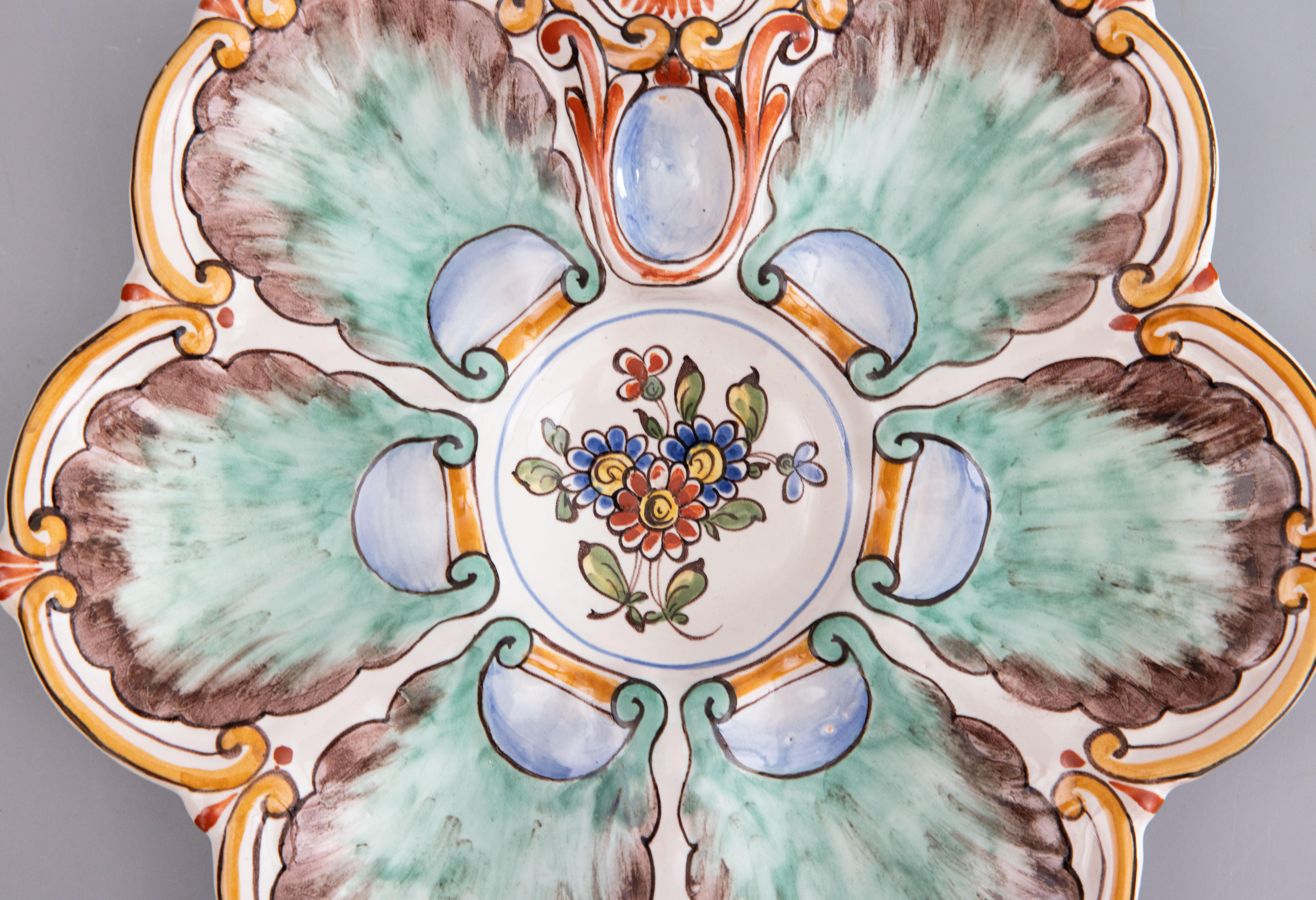 A gorgeous French hand painted oyster plate of the faïence factory of Saint-Clément, circa 1890. Signed on reverse. This lovely plate is hand painted with seafoam green wells, a golden yellow-orange border, and a floral center well. It displays
