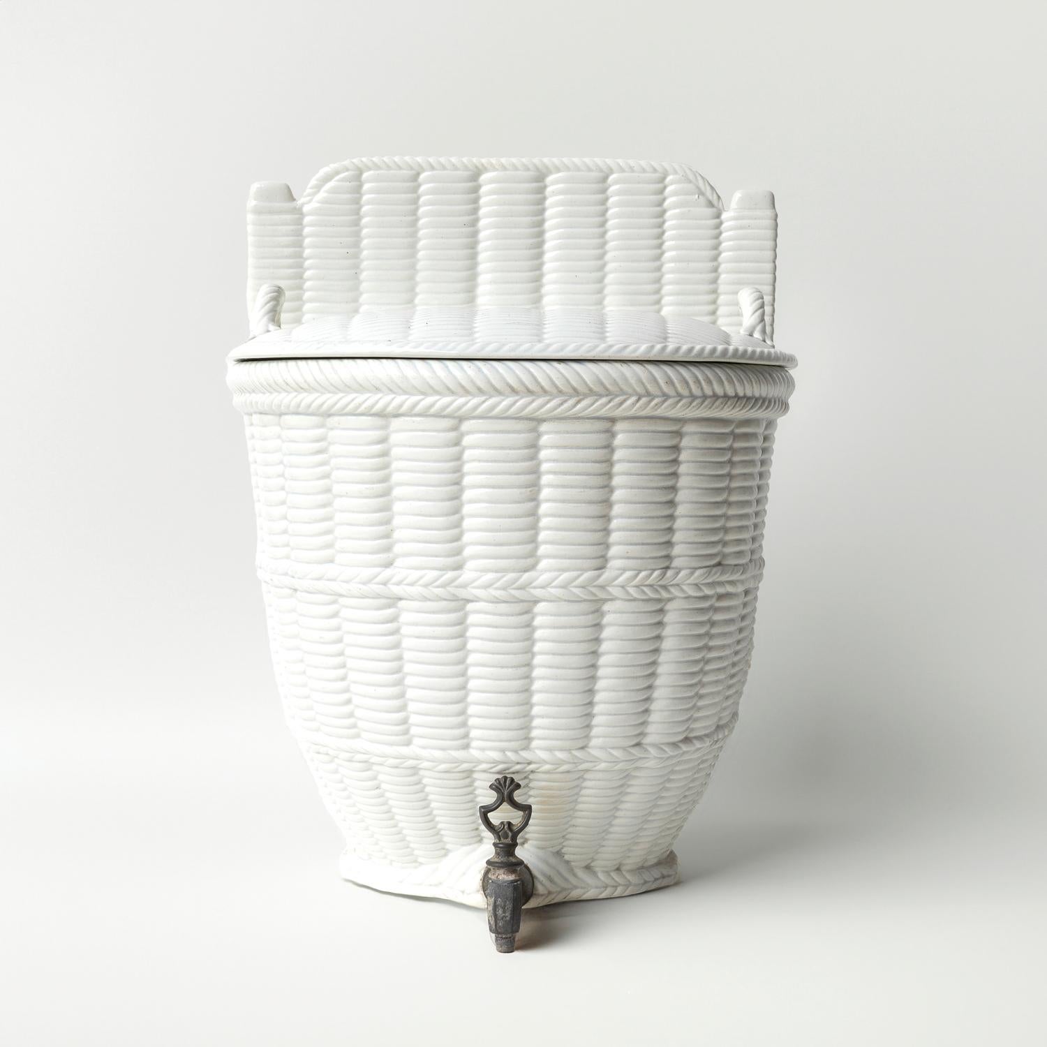ANTIQUE LAVABO

Made from white glazed earthenware in the form of a woven basket with a decorative metal tap.

Originally designed to hold water or other liquids which could then be dispensed using the tap.

The underneath is stamped with the mark