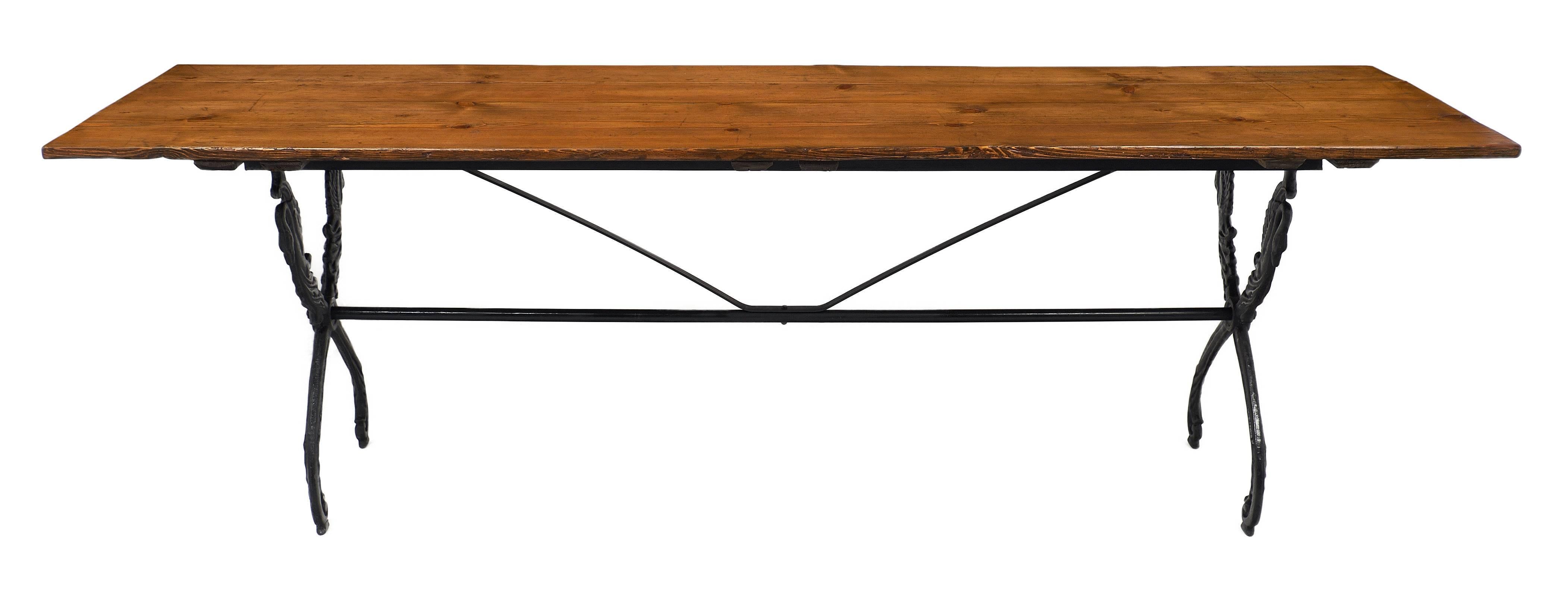 From the Rhone Valley, French antique farm table with iron base, finely cast, representing swans in the Restauration style connected by a stretcher. The plank top is of fir with a hand rubbed wax finish. We love the perfect balance of this