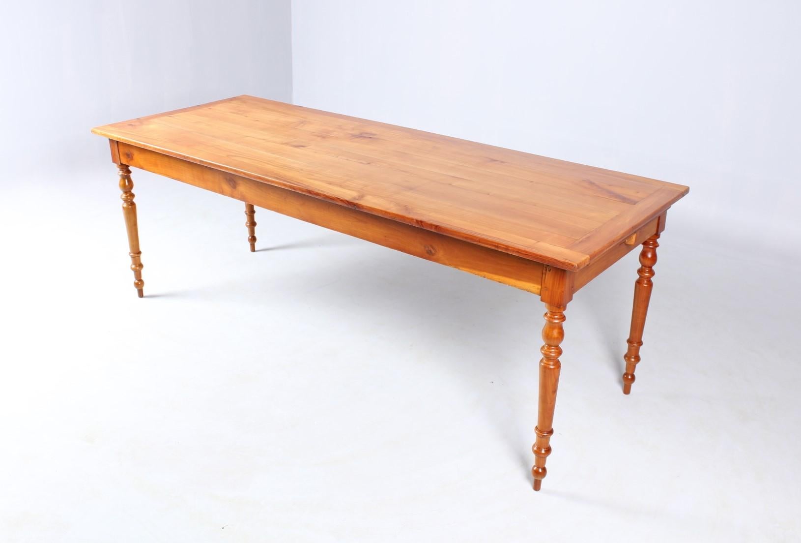 Early 20th Century French cherrywood dining table, Turned legs. Top with slightly lower extension as a shelf for bread, flowers or wine. On the other front side there is a drawer.

Farmhousetable. Made in France, about 100-120 years old.

The