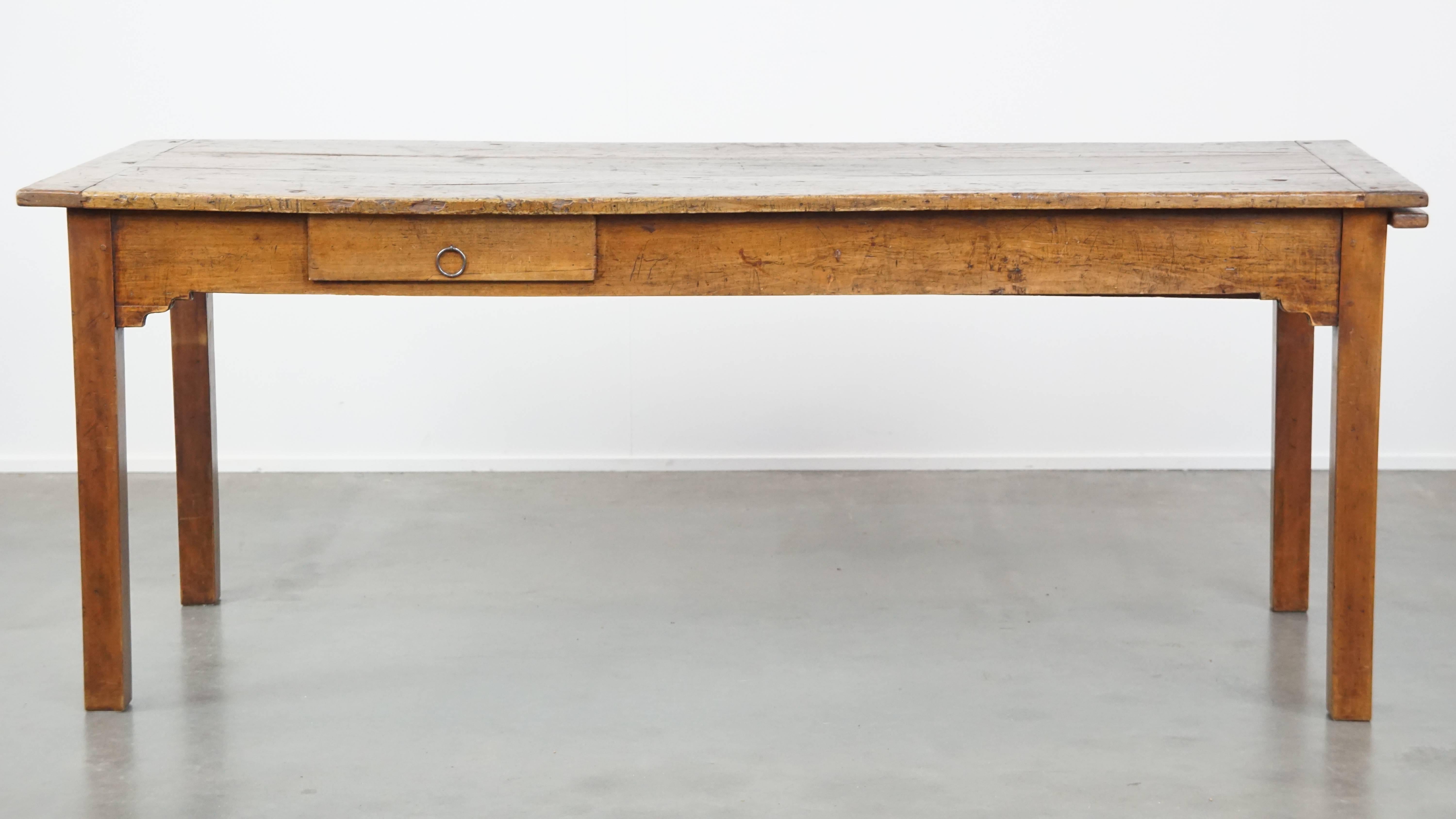 Offered here is this antique French farmhouse dining table from the early 19th century, featuring two drawers and a breadboard / extendable leaf. In our opinion, this French antique farmhouse table is a must-have for any interior. Over the years, it
