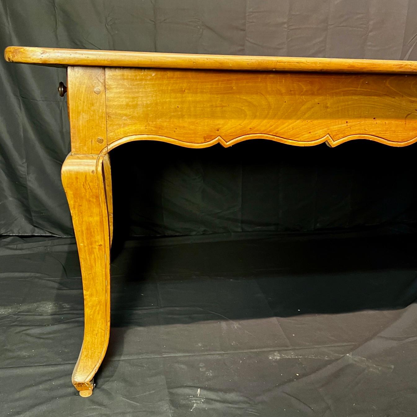 This 19th-century French farmhouse dining table is a charming example of rustic craftsmanship and practicality. Constructed from lovely walnut wood, the table features a warm, aged patina that highlights the natural grain and character of the wood. 