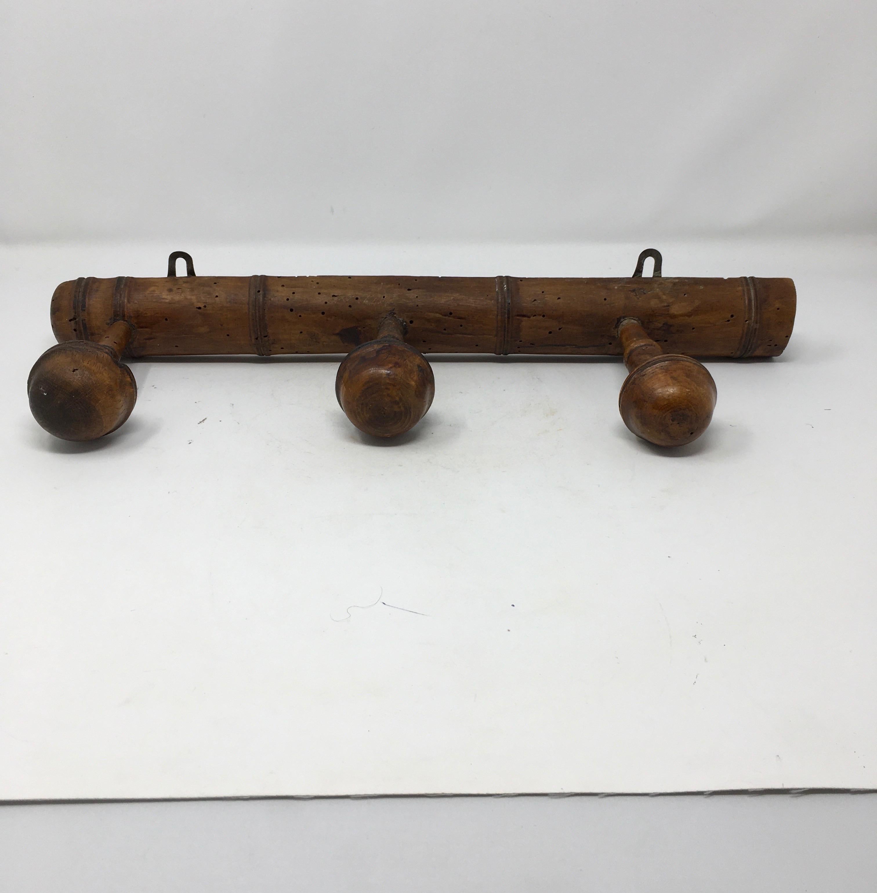 Found in the South of France, this rustic antique French faux bamboo coat/hat rack is manufactured with three pegs and two iron hooks on the base. Rustic farmhouse charm, yet sturdy and versatile for modern day.

This piece weighs 1 lb.