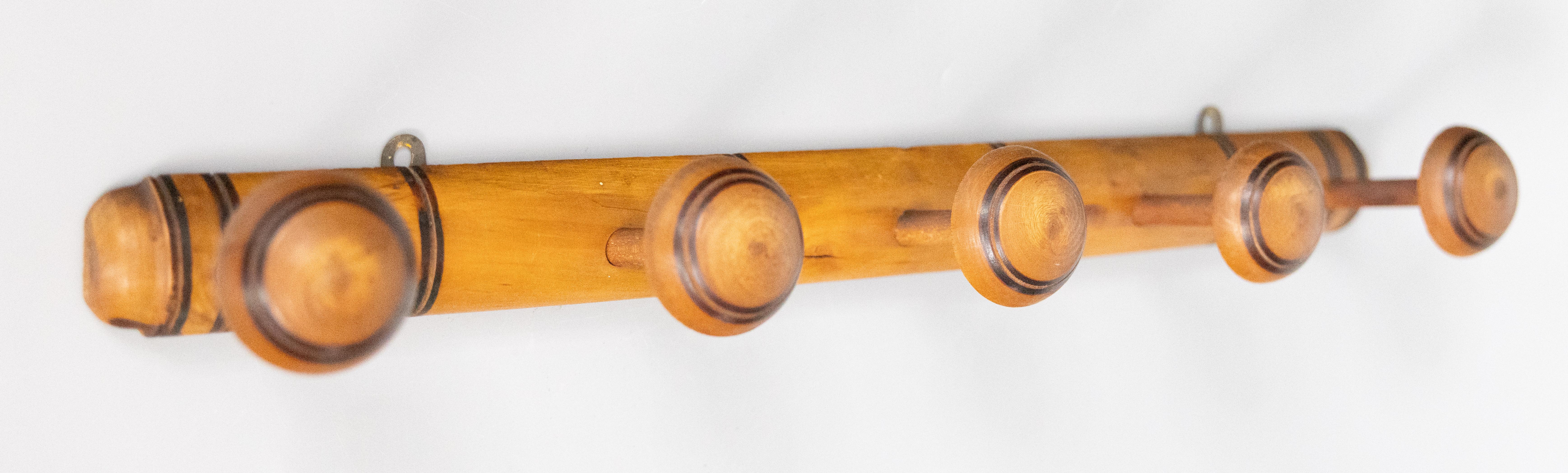 Superbe porte-manteau ancien en faux bambou sculpté, vers 1920. Cette belle étagère a conservé sa surface et sa patine d'origine et comporte cinq patères tournées à la main, parfaites pour suspendre des vestes et des chapeaux dans une entrée ou un