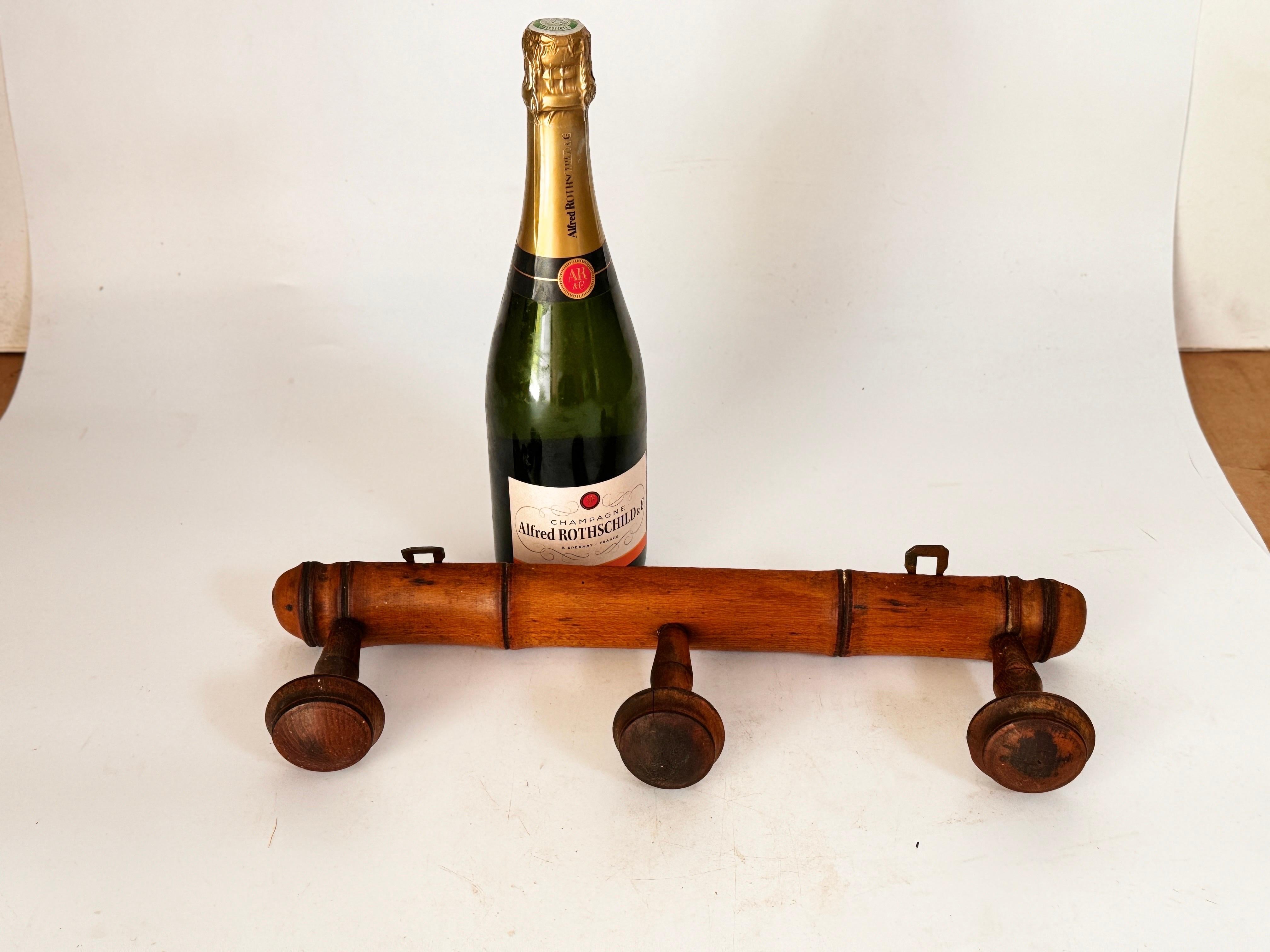 A superb antique French faux bamboo carved wood coat rack, circa 1920. This fine rack retains the lovely original surface and patina and has four hand turned pegs, perfect for hanging jackets and hats in an entryway or mudroom.