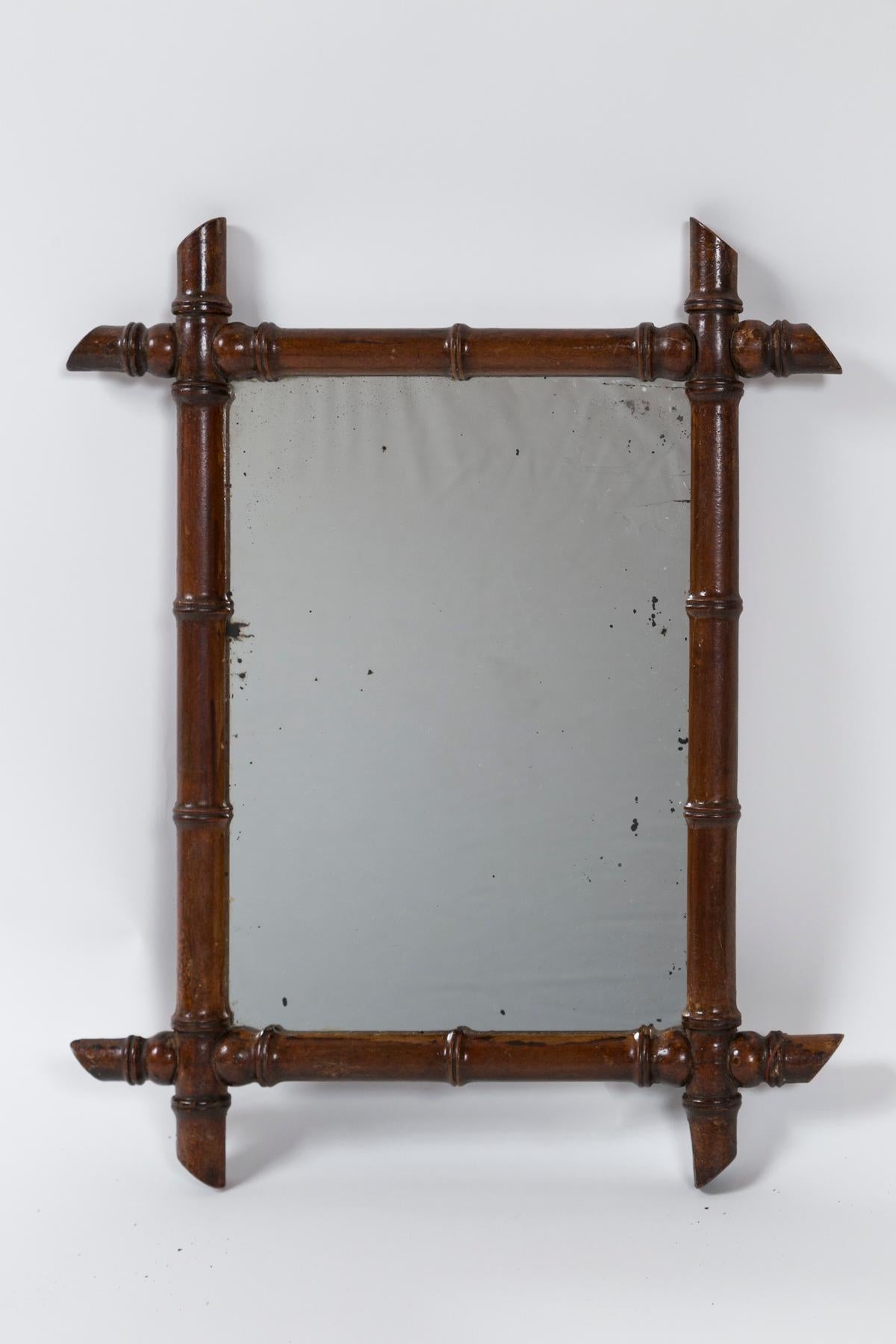 Antique French Faux bamboo mirror, circa 1910. Original glass with new backing. Dark brown wood, turned to simulate bamboo. A classic country French design.