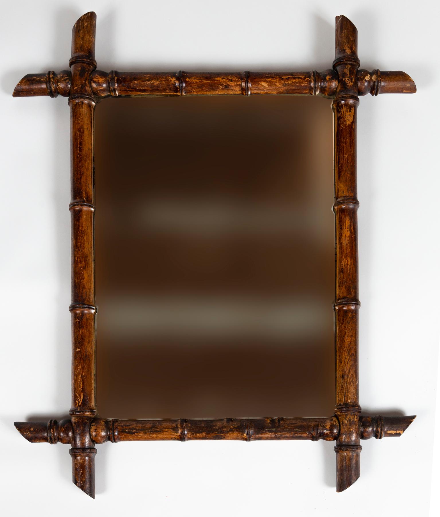 Miroir ancien en faux bambou, vers 1910. Cadre en bois tourné pour reproduire le bambou. Verre d'origine et support en bois. 