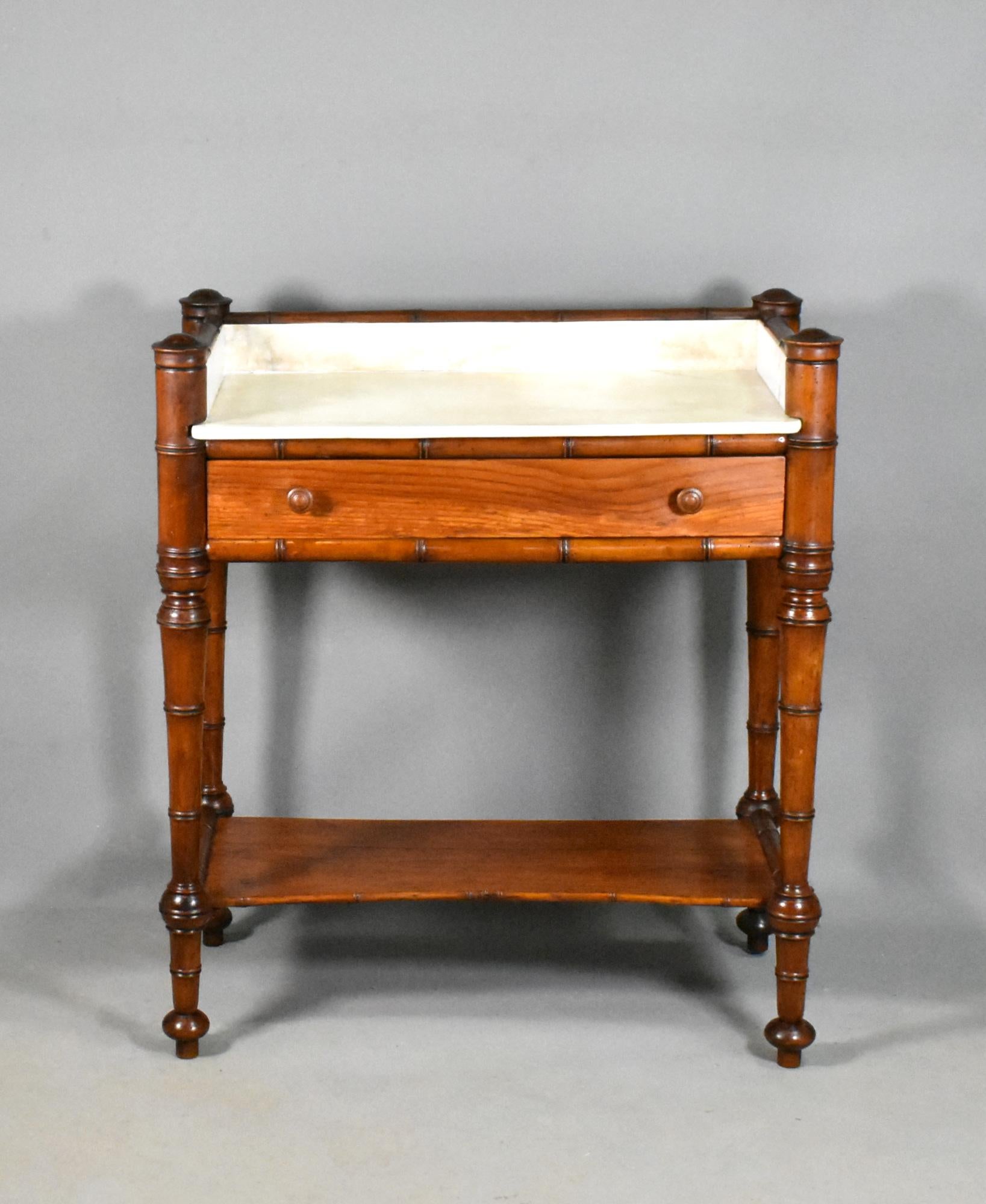 Antique French faux bamboo washstand 

This delightful Faux Bamboo Washstand retains its original white marble top, below which there is a full-width drawer made of pine with turned drawer pulls. 

The turned tapered legs lead down to a pine