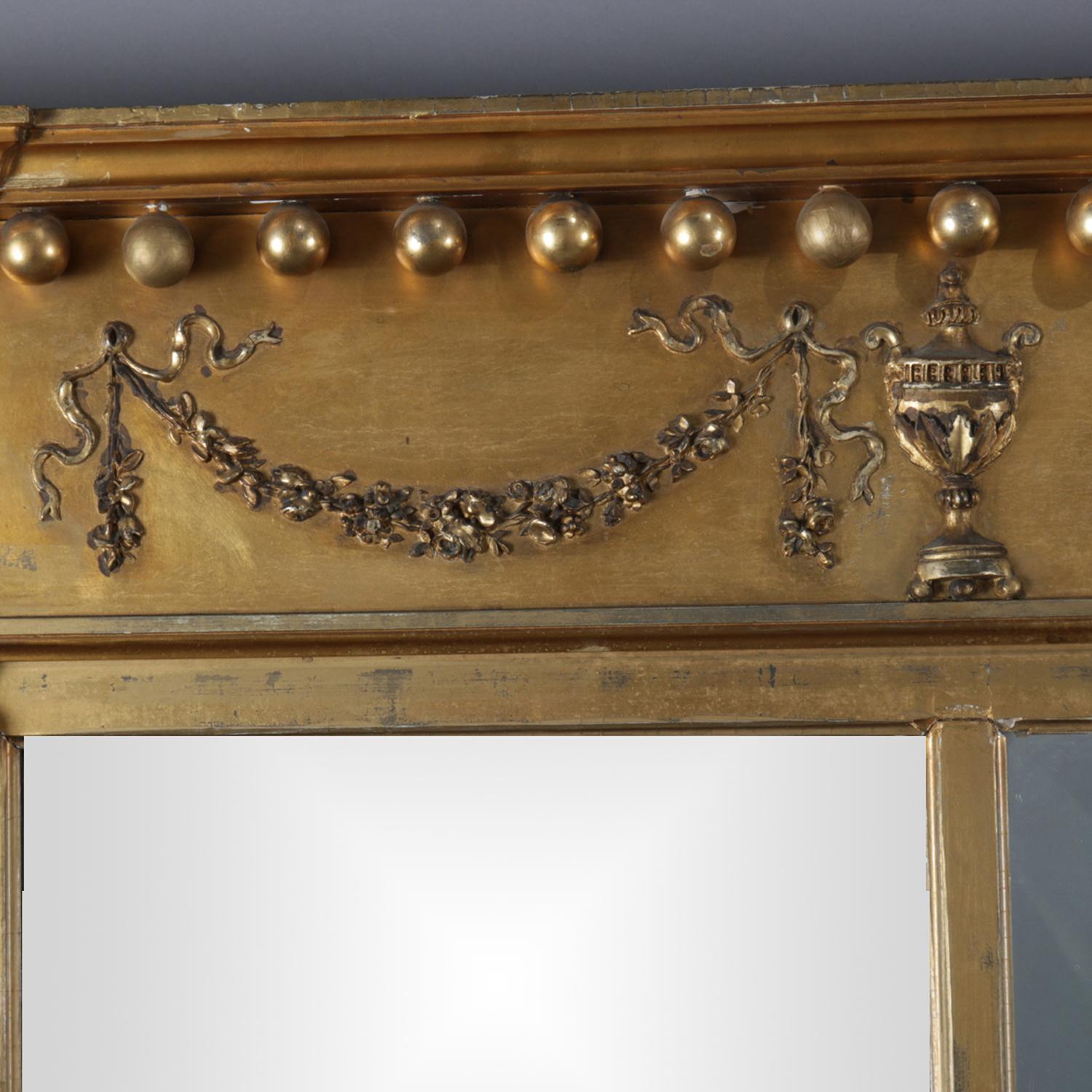 Antique French neoclassical giltwood triptych mirror features crest with ball drop finials and decorated with garland and urn decoration flanked by patera over Corinthian column-form sides, circa 1890.

Measures: 36.5