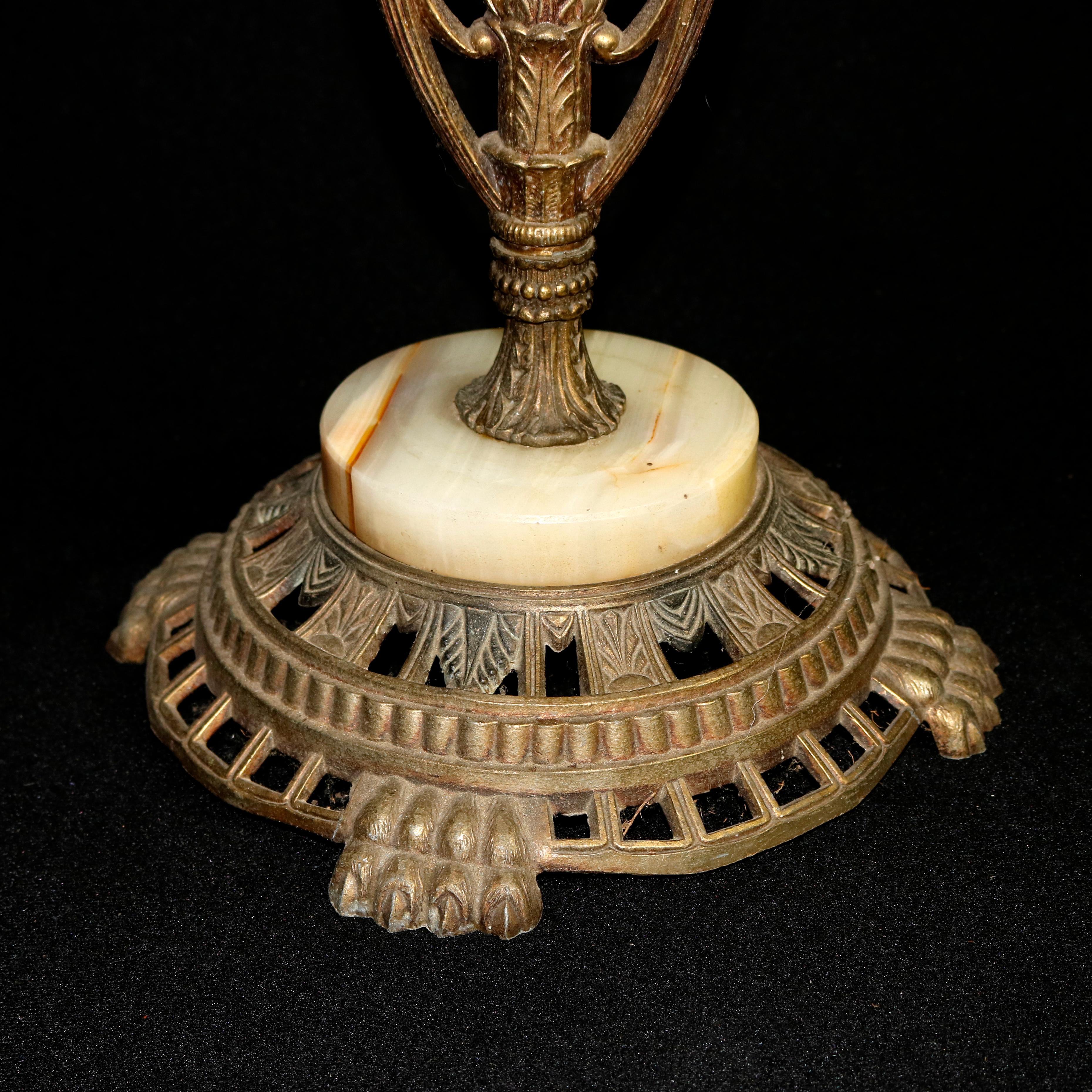 An antique French Art Nouveau smoking stand offers figural cast bronze frame with floral handle over woman flanked by foliate form arms each supporting a tray and surmounting round onyx table with twisted column having flanking peacocks and raised